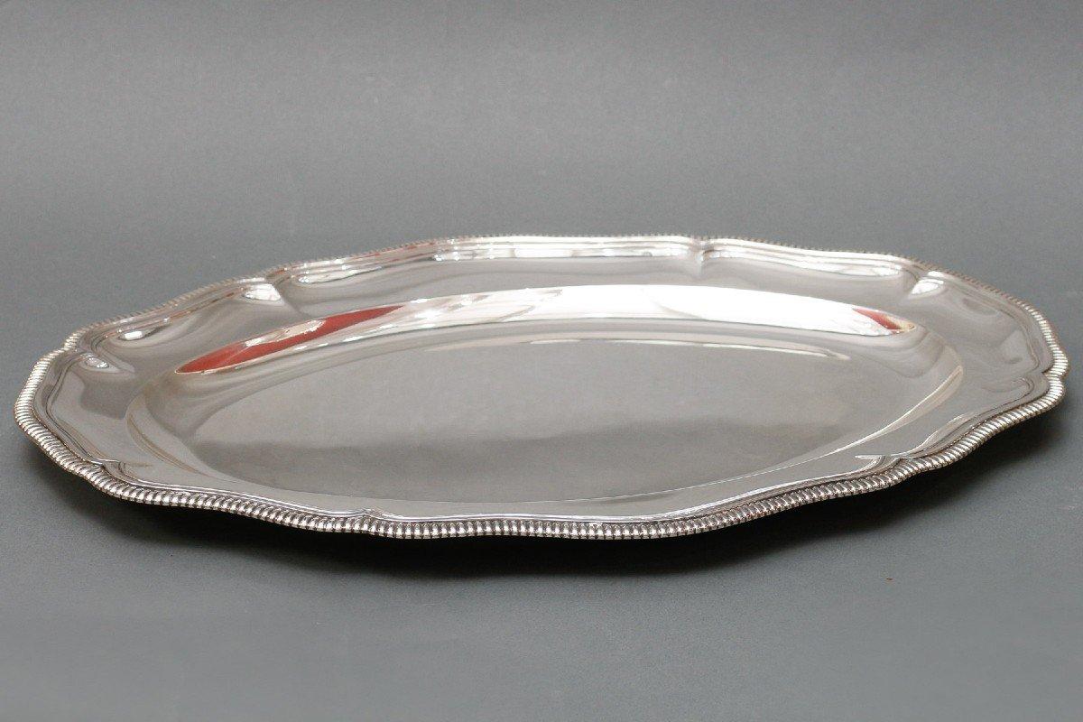 Large oval dish in solid silver, model with pinched ribs, double fillets, half-hollow, bordered by a large gadroon, and mounted with a hammer.
Dimensions: length: 46cm - Width: 32.5 cm - Height: 2.5 cm
Material: Silver 1st title
Weight: 1210