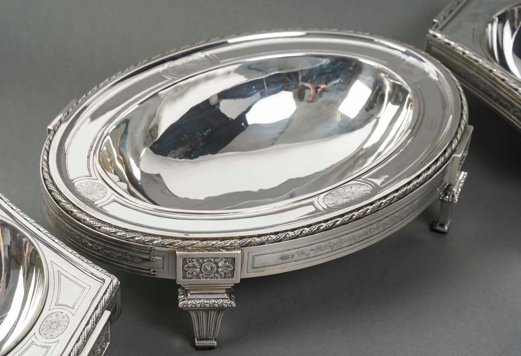 Solid silver centerpiece with neoclassical decoration composed of two triangular planters with curved ribs and an oval planter, each resting on fluted pilaster feet.

Dimensions: Oval planter L 366 cm - D 26 cm - H 9.8 cm

Triangular planters L 26