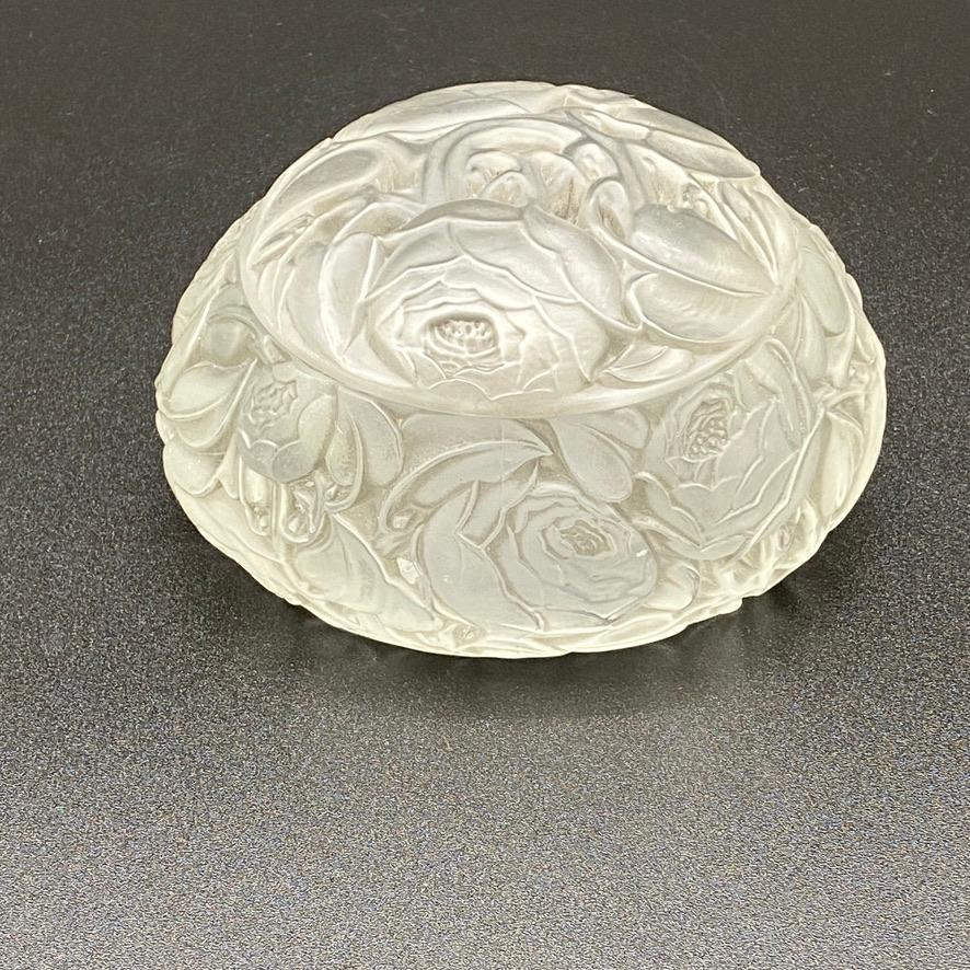 The diner boxe is a strong Art Deco design by R.lalique.

The roses cover the bottom and the lid of the boxe .

The boxe is molded in thick glass with a strong mould design.

The boxe has a light grey patina and is is signed with a sand