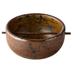 Bol percé d'une tige de bois