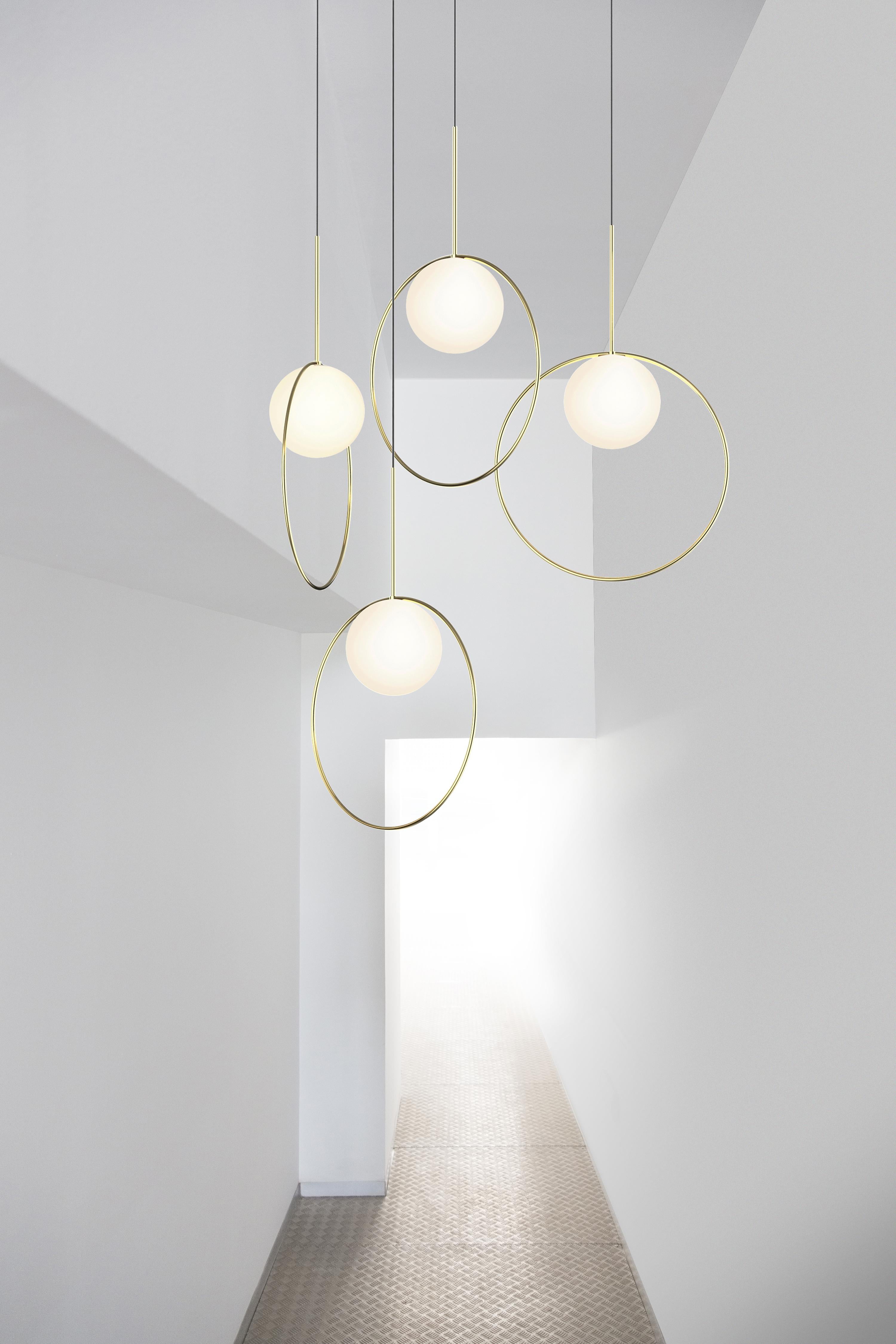 S'inspirant des bijoux à pendentifs, Bola Halo est un luminaire suspendu à l'expression unique, doté d'un anneau chromé qui s'équilibre délicatement au-dessus de son élégant abat-jour en verre opalin tout en laissant transparaître son environnement.