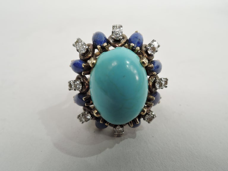 Bold and Modern cocktail ring. Oval turquoise bordered by teardrop lapis alternating with paired solitaire diamonds in raised mounts forming band. Mounts and band are yellow 14k gold. United States, ca 1960s.