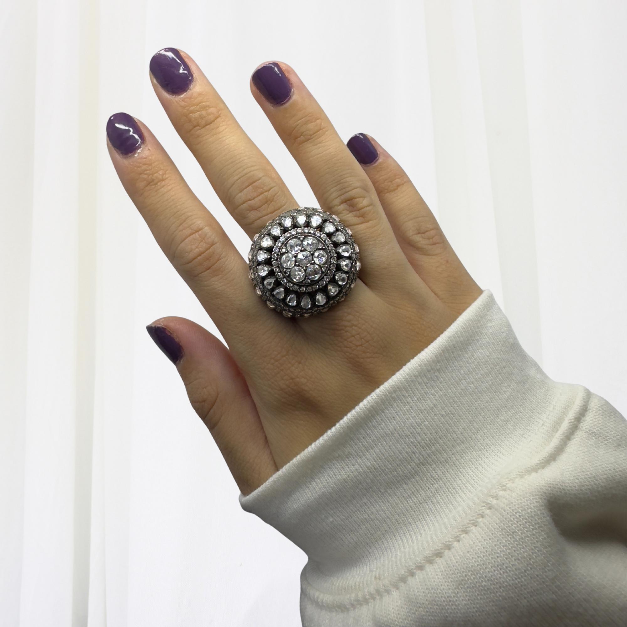 Cette extraordinaire bague de cocktail est une véritable pièce d'apparat, mariant un design audacieux d'inspiration vintage à un savoir-faire artisanal luxueux. Fabriquée en or jaune 18 carats avec une partie supérieure en argent, la bague présente