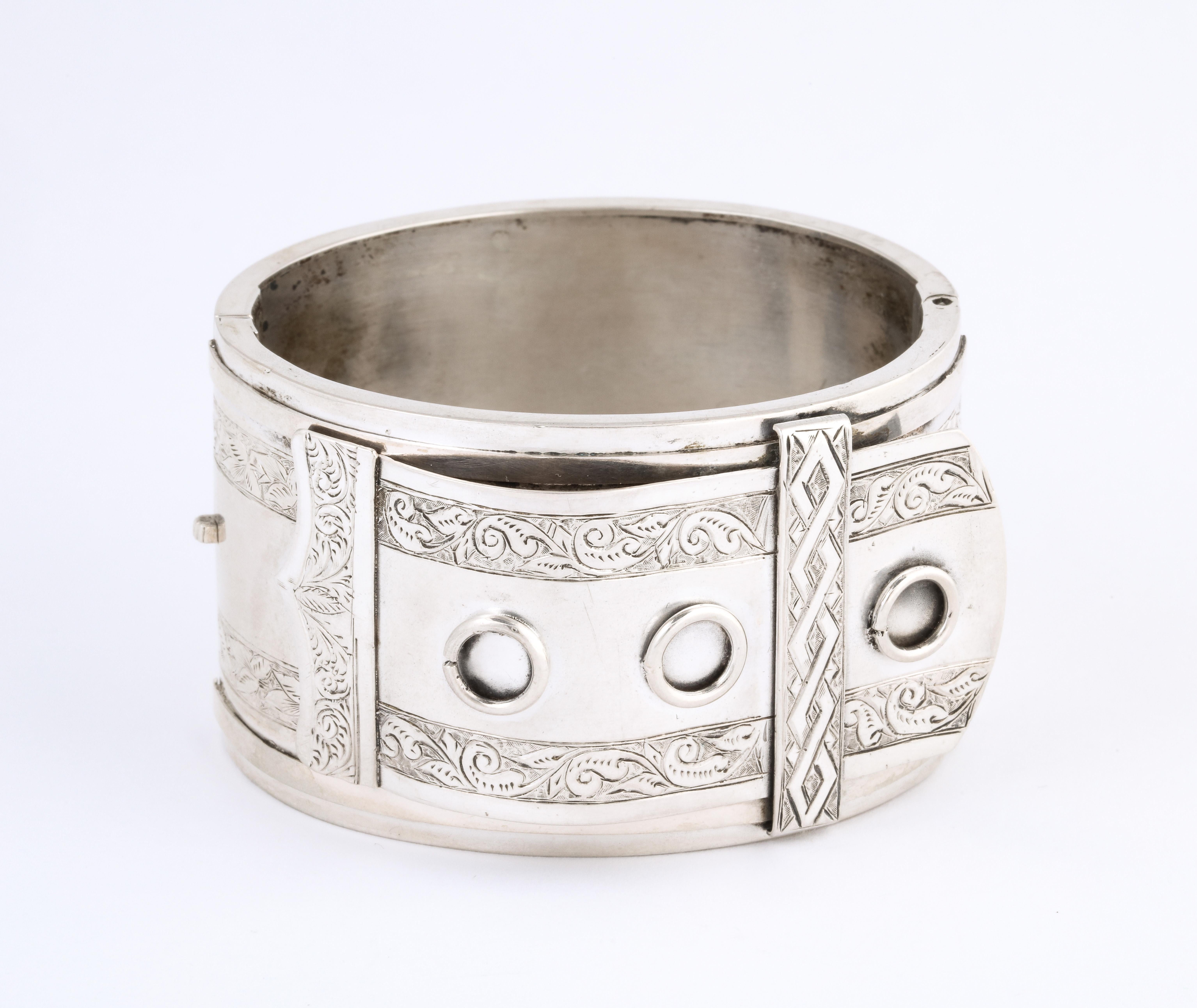 Silver cuff collectors take note of this buckle motif cuff in a scarce design. It is a bold bracelet that measures 2 inches in height. Created in the United Kingdom during the silver jewelry explosion. It dates to 1860-1880. At this time Queen