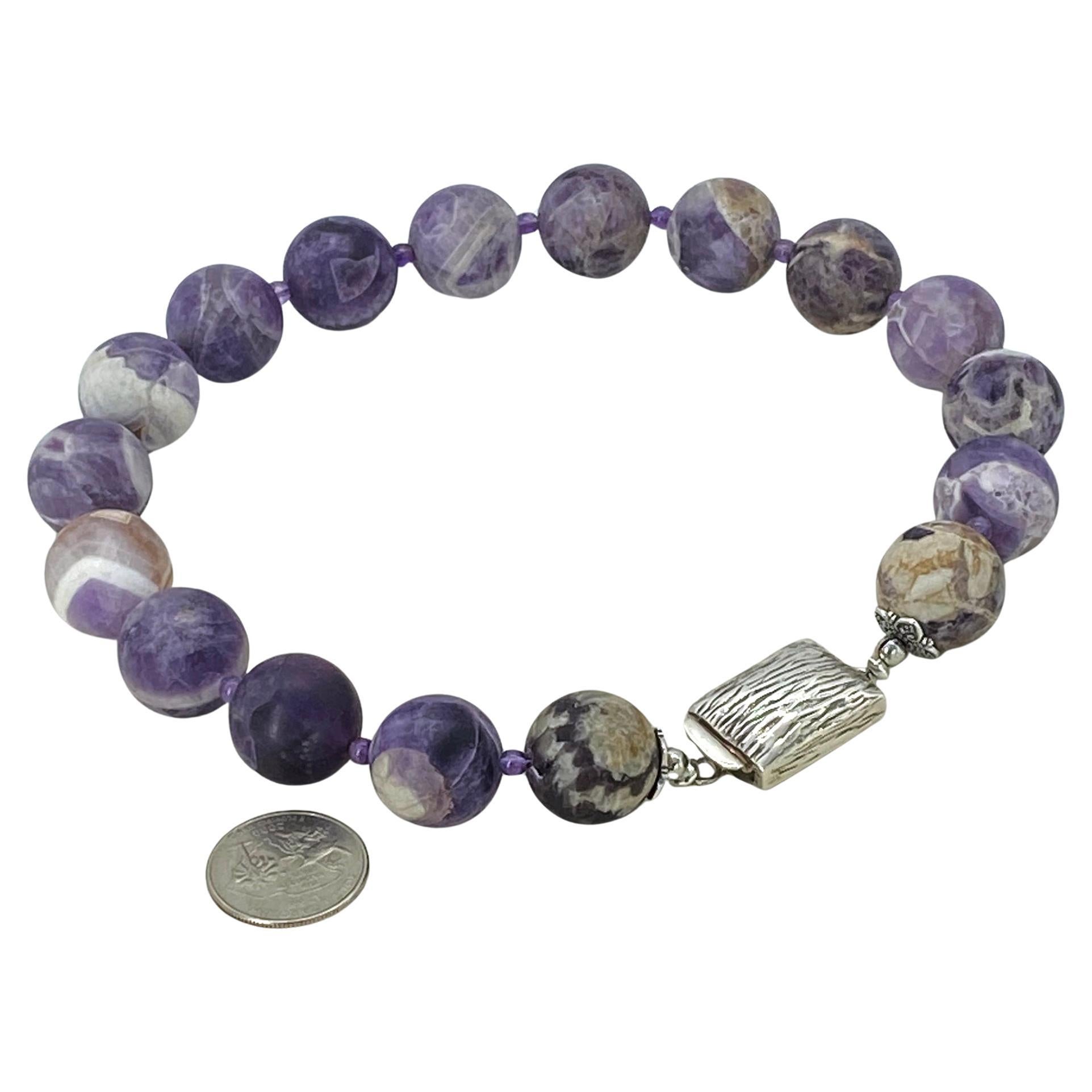 This is a strand of Cape Amethysts* forming a bold necklace. We created it with 21mm  smooth Cape Amethysts and 4mm natural round translucent amethysts. A large sterling silver box clasp with wood grain texture is custom made. Imagine this bold