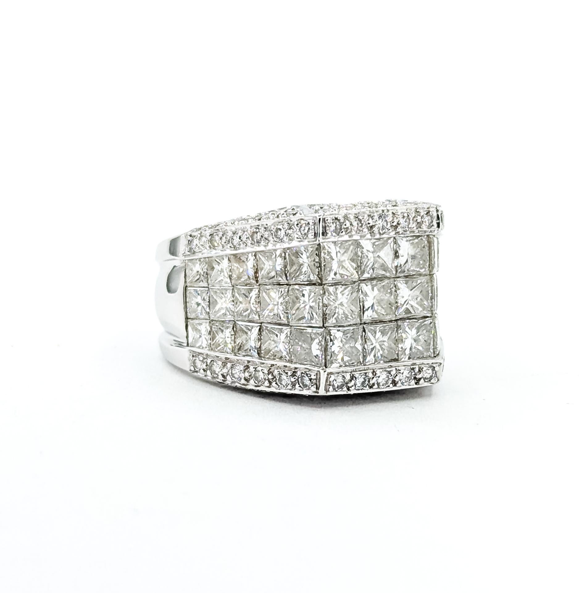 Cette bague audacieuse est fabriquée en or blanc 18 carats et présente un sertissage invisible complexe de diamants de taille princesse et de diamants ronds de taille brillant. Les diamants totalisent 4,00 carats, presque incolores avec une pureté