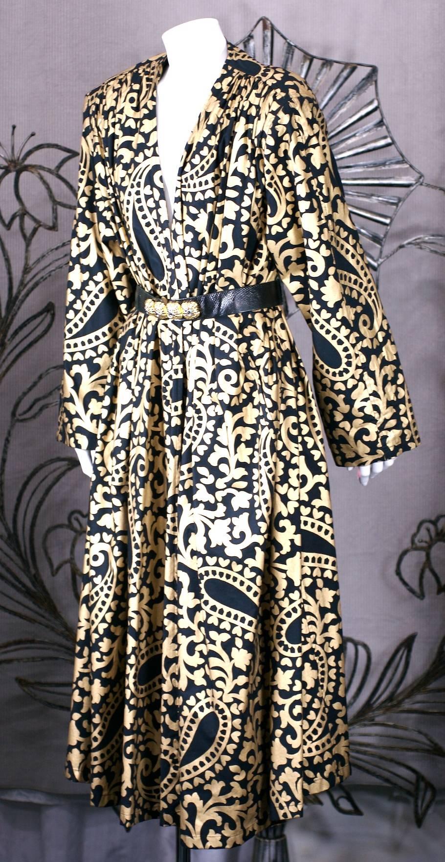 Bold Italian Gold and Black Paisley Print Coat in glazed cotton with full cut sleeves. Styled as a fully cut swing coat falling from large shoulder pads with no closures. Requires belt (not included). 
Graphic 80's styling and presence. Fits a