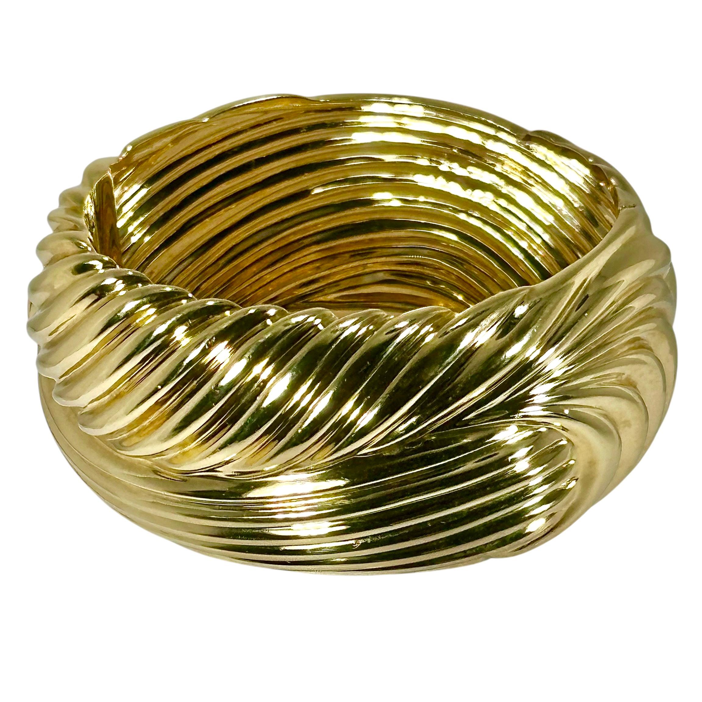 Cet audacieux bracelet à bombe en or jaune 14K de la fin du 20e siècle est visuellement massif et se tient très bien en main. Des bandes cannelées profondes au toucher organique couvrent toute sa surface. Des designs aux motifs complètement