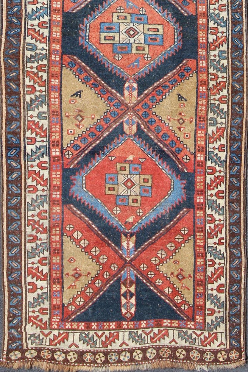 Persian Heriz antique gallery rug with Sub-geometric medallion design in colorful tones, rug gng-4774, country of origin / type: Iran / Heriz, circa 1910

This antique Persian Heriz runner, from northwest Iran, displays a geometric medallion