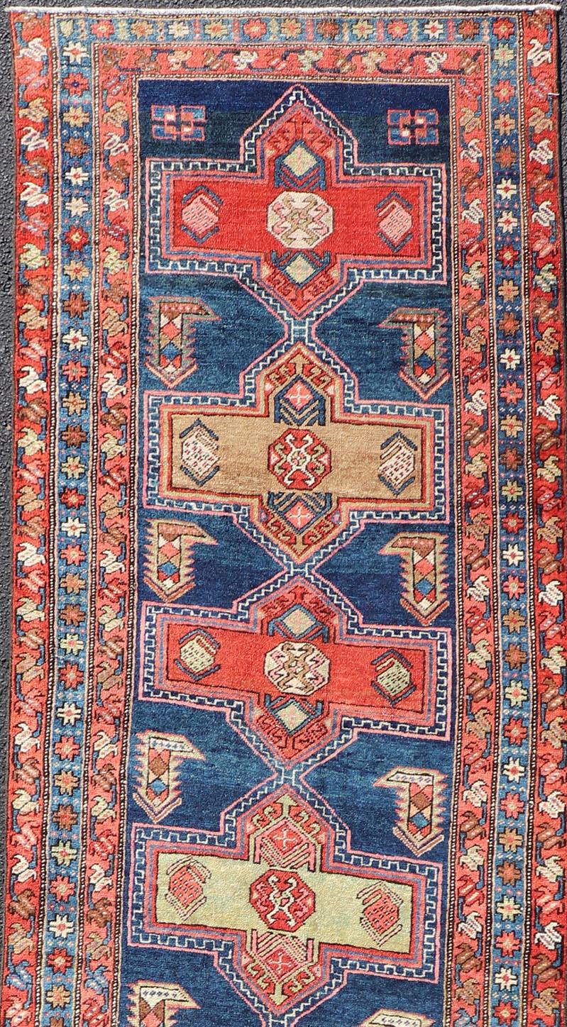 Mesures : 3'5 x 13'4 
Tapis de course persan ancien à motifs de médaillons dans des tons rouges et bleus. Keivan Woven Arts / tapis EMB-22195-15097, pays d'origine / type : Iran / Heriz, vers 1910

Cet ancien chemin de table persan Heriz, originaire