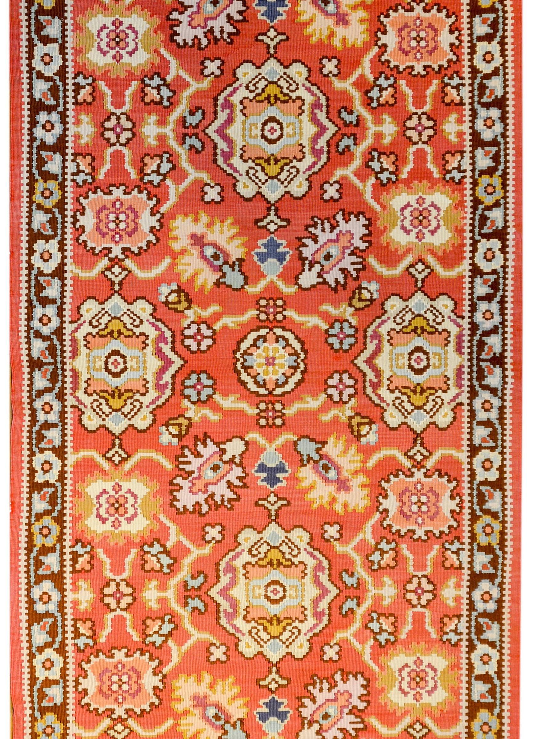 A bold mid-20th century Turkish Bessarabian runner with all-over trellis floral and vine pattern woven in crimson, dark burgundy, light and dark indigo, gold, and white vegetable dyed wool. The border is sweet, with a smaller scale floral and vine