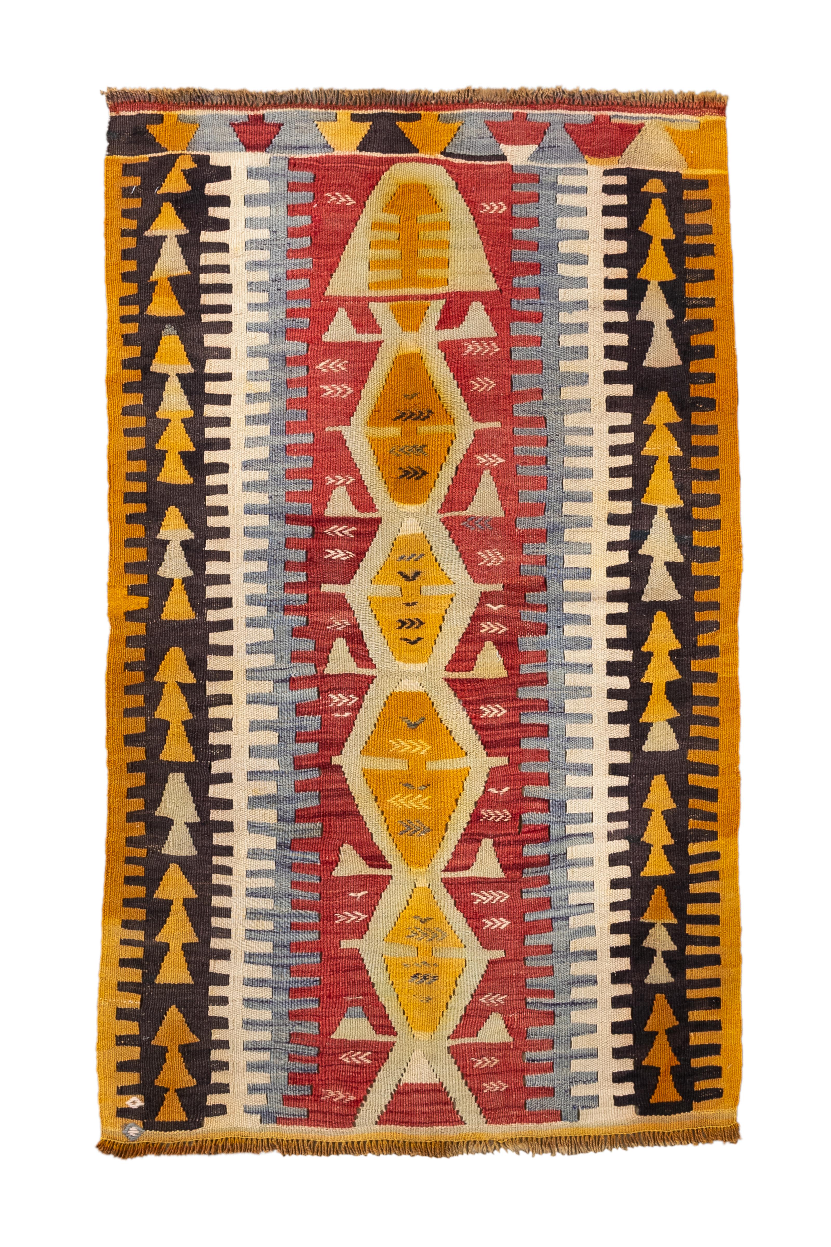 Un Kilim turco della metà del XX secolo, dinamico e altamente collezionabile, caratterizzato da un'audace colonna centrale di medaglioni a diamante a gradini nei toni del senape e dell'oro, delimitata da forti motivi avorio, ruggine e blu ardesia. I