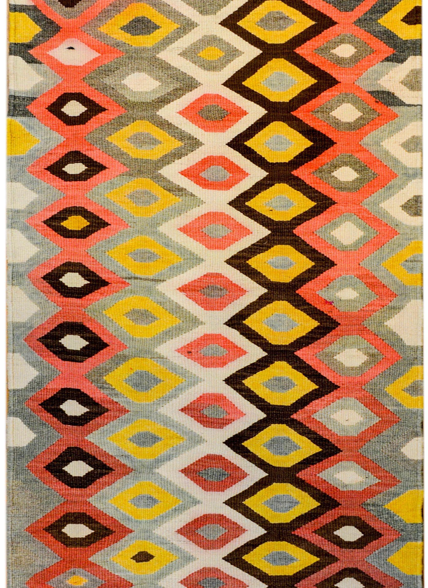 A bold mid-20th century Zarand Kilim rug with a fantastic large-scale diamond pattern woven in brown, gold, white, grey, and pink colored vegetable dyed wool. There is no traditional border, but the 