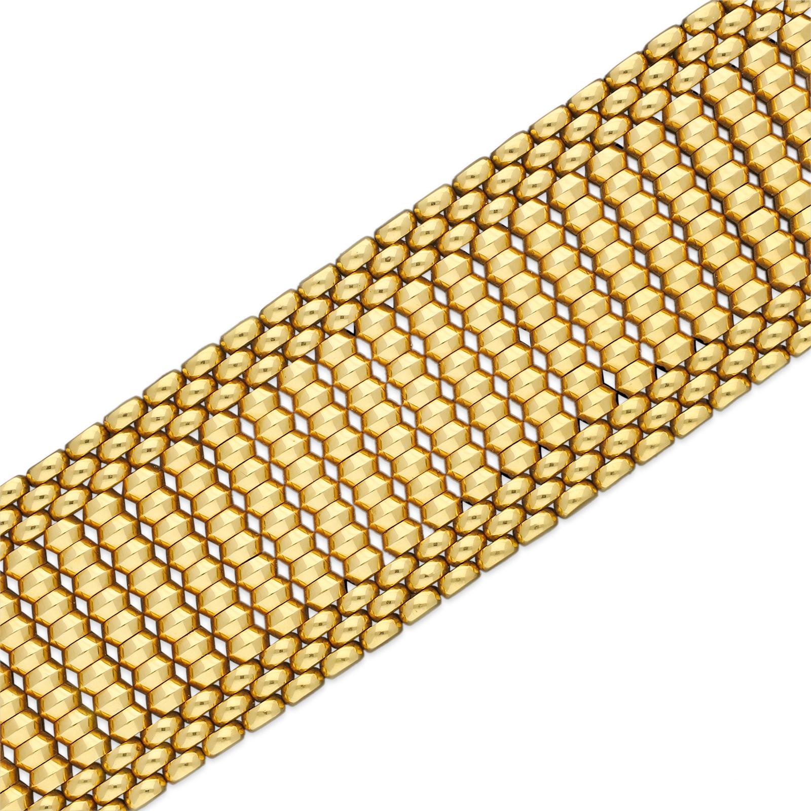 A bold Retro wide gold bracelet c.1950s of highly flexible design, composed of vertical bars of three dimensional geometric form, edged by three rows of semi-circular gold beads, to a concealed tongue and box clasp and double safety catches.

18ct