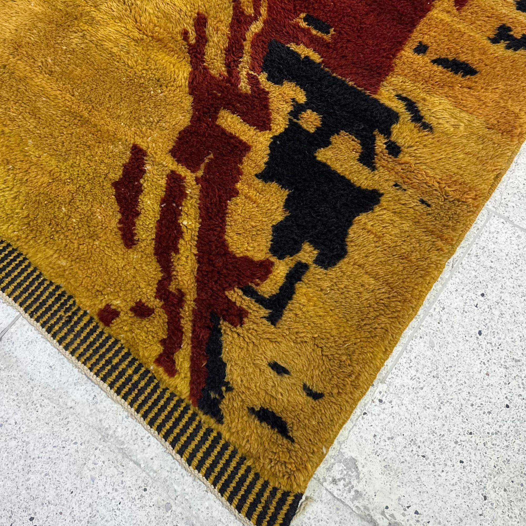Transformez votre espace avec le Celestial Canvas, un tapis marocain shag audacieux qui célèbre l'expression artistique et l'artisanat intemporel. Cette pièce vibrante présente une riche toile de fond orange ornée d'un motif abstrait noir et rouge,