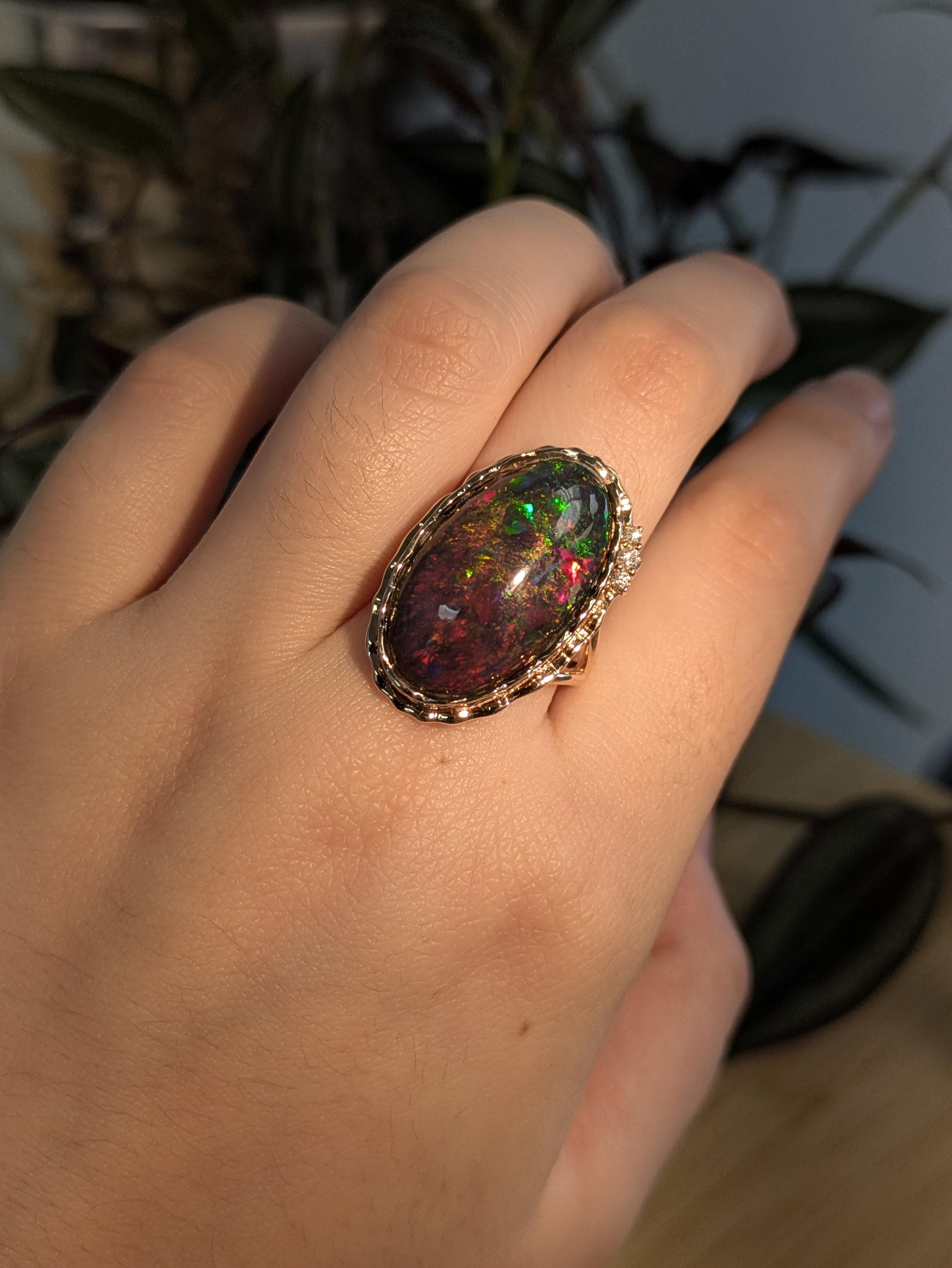 Cette bague unique de 10,73 ct d'opale noire, riche en teintes irisées et encadrée d'un or rose chaleureux, est l'expression d'un style puissant. Le cabochon lisse de l'opale est serti en chaton pour une touche contemporaine, complété par trois