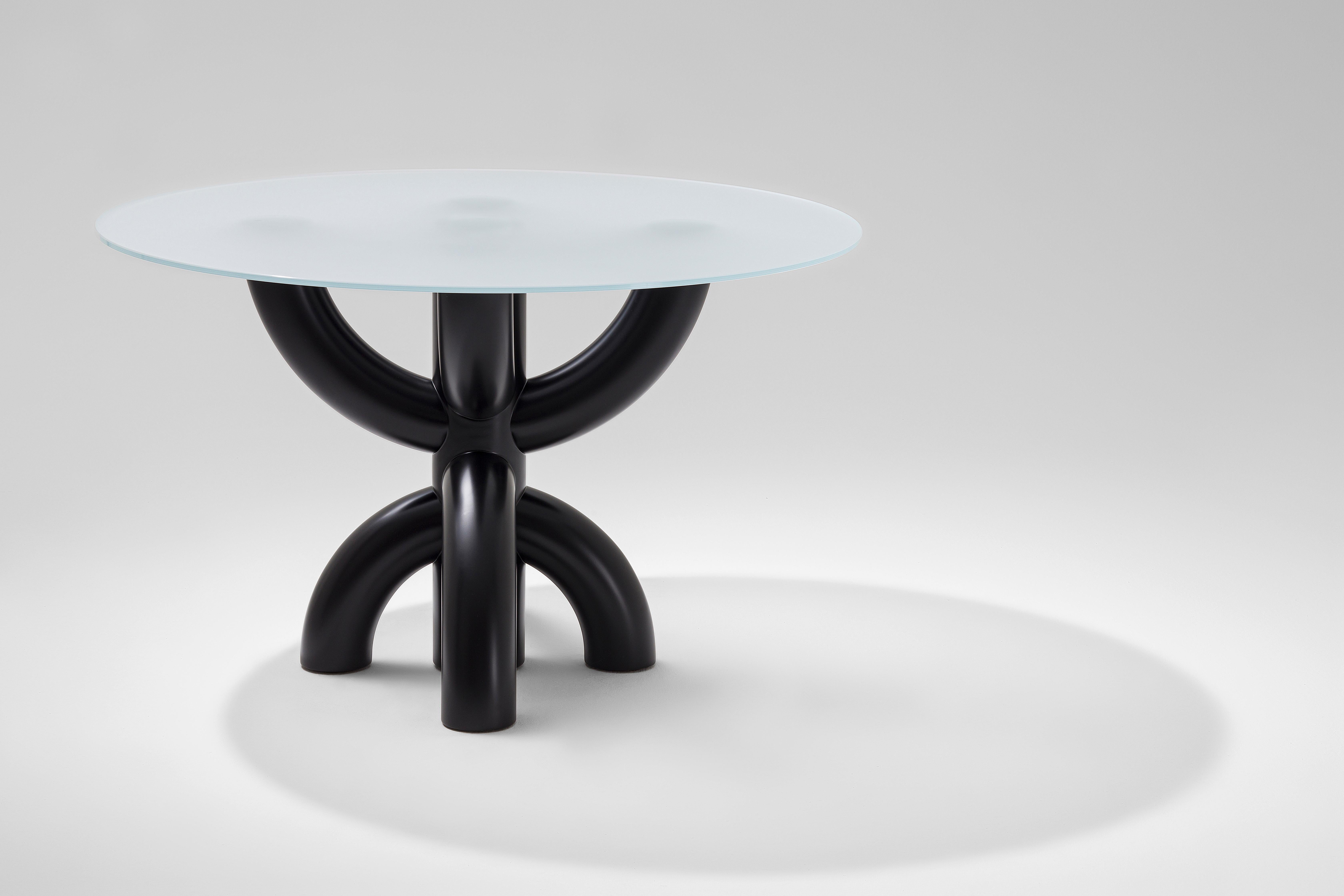 Bold table by Tolga Sencer
Dimensions: 130 x 130 x 85 cm
Materials: black lacquer wood, satin glass over wood top

In Bold collection, bodies have strong symmetrical structures. Rotations of thick and broad elliptic lines on a single axis