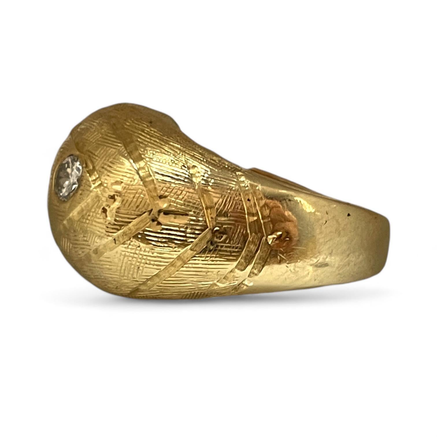 This one-of-a-kind vintage gold ring captures the eye with its sculptural design and fine detailing. The textured surface showcases a captivating pattern, while a row of sparkling diamonds adds a touch of luxury and brilliance. Perfect for making a