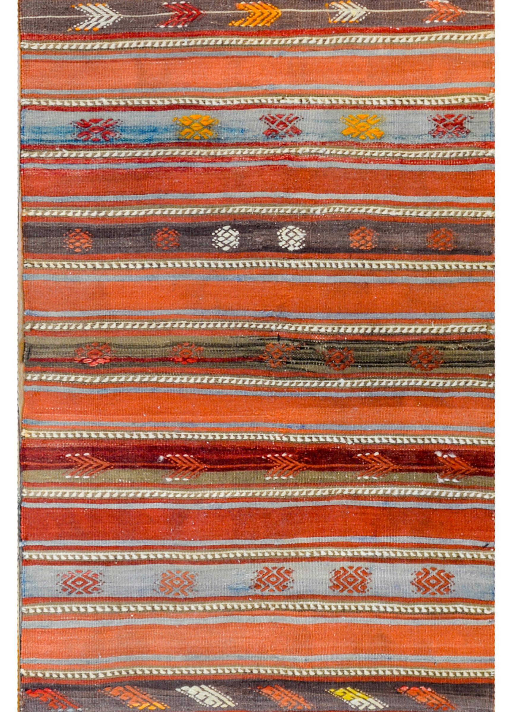 A bold vintage Turkish Konya Kilim runner with alternating solid and patterned stripes woven in crimson, orange, light indigo, brown, and white vegetable dyed wool.