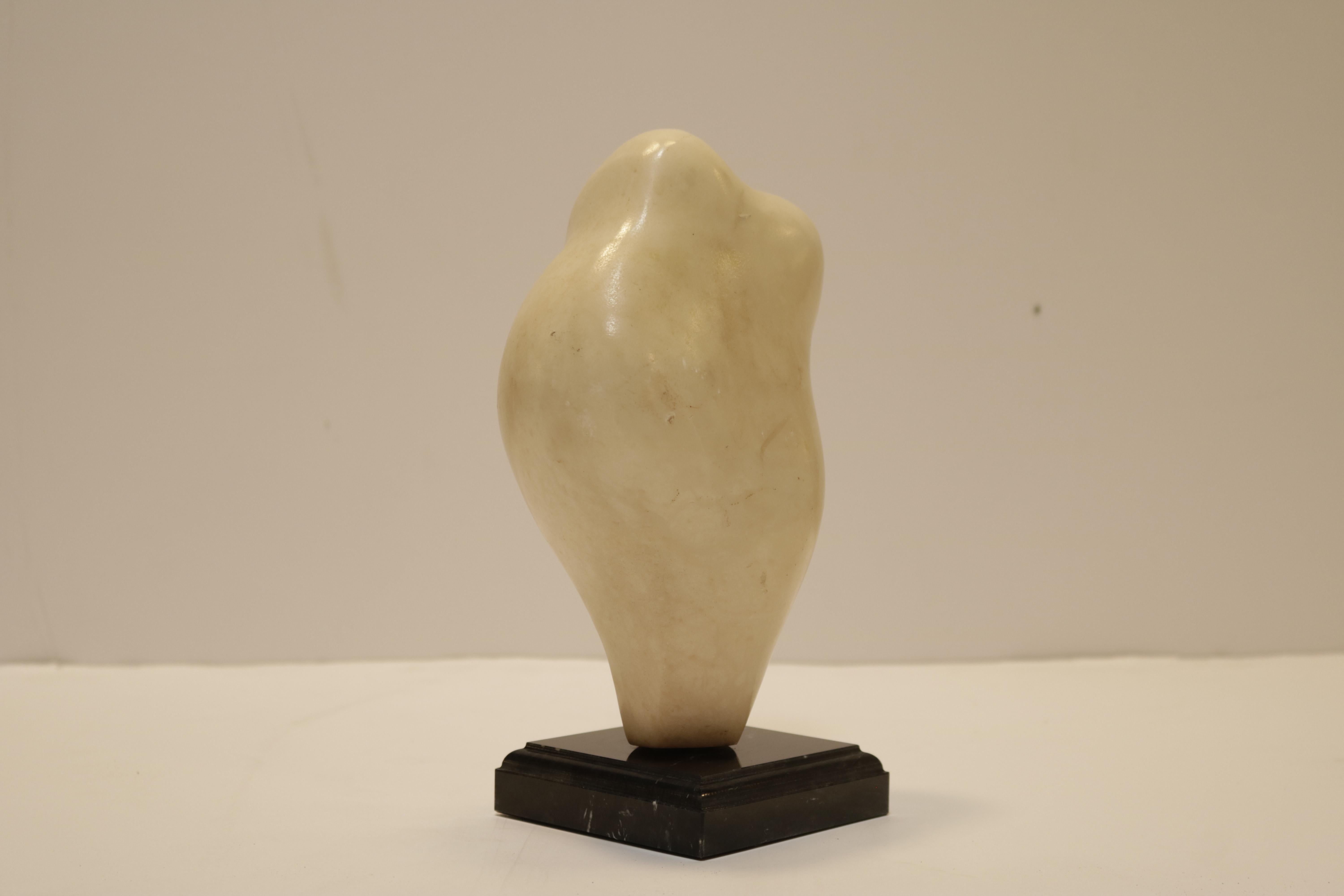 Small carved figurative white marble sculpture on a black marble base. Istvan Toth was a Hungarian artist who lived and worked in the Hollywood Hills from the 1960s through the 1990s.