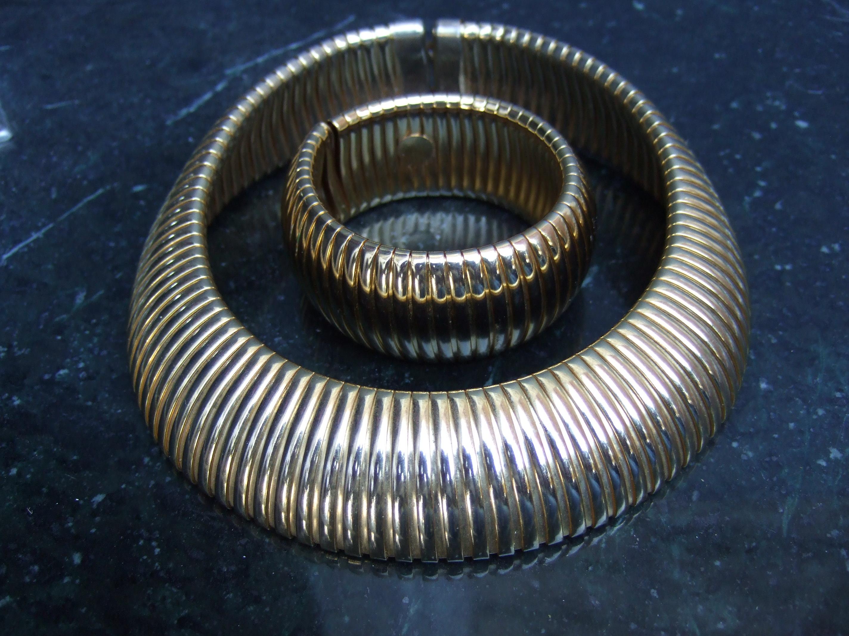 Dramatic wide gilt metal stretch band choker & cuff bracelet c 1980s 
The bold large scale ensemble is designed with wide vertical stretch bands
that expand slightly 

The severe minimal design makes a very striking accessory 

Measurements:
The
