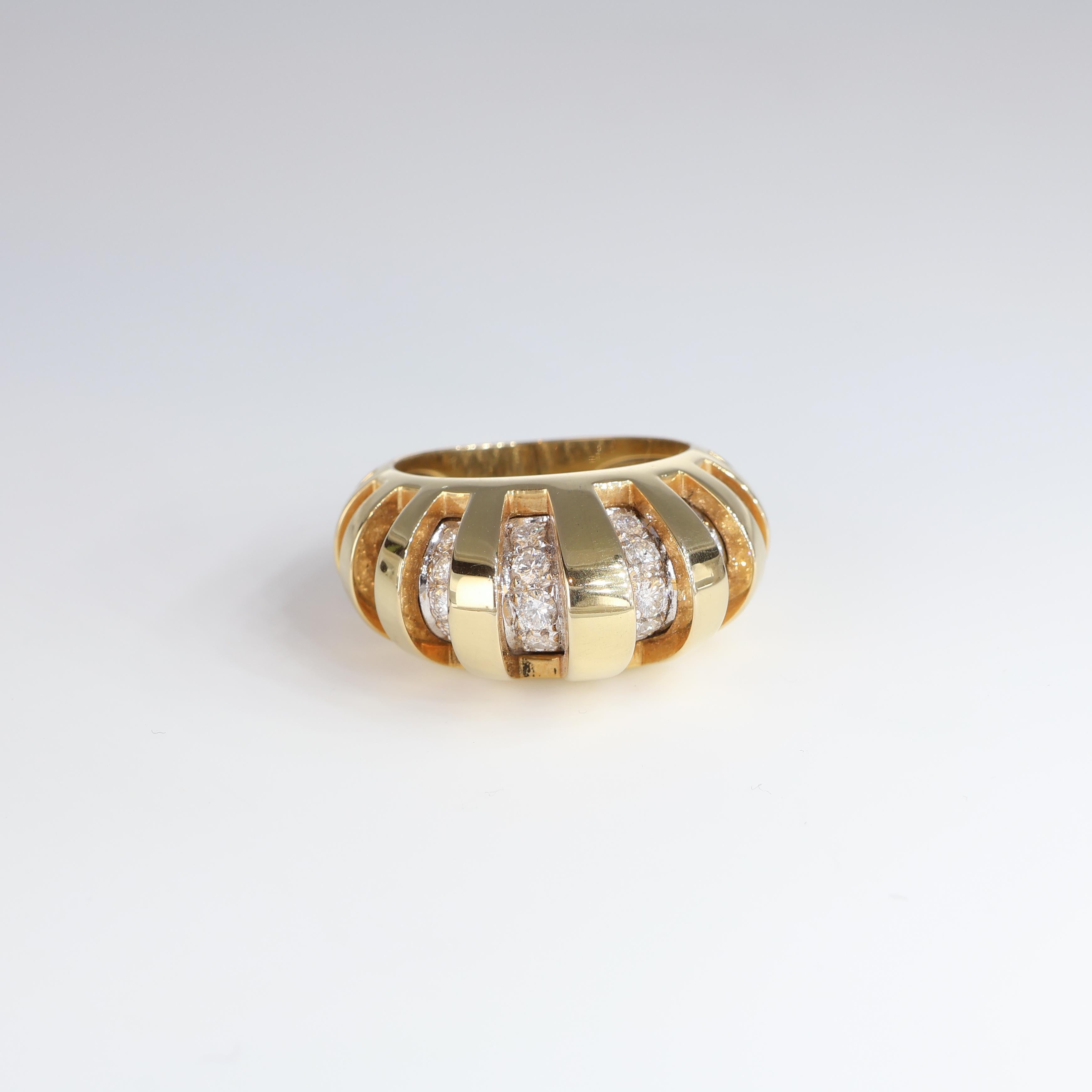 This captivating 18kt yellow gold band ring is a true statement of timeless elegance. The bold yet intricate design features alternating open spaces and polished gold bars that create a dynamic and sculptural look. Nestled between the gold segments,