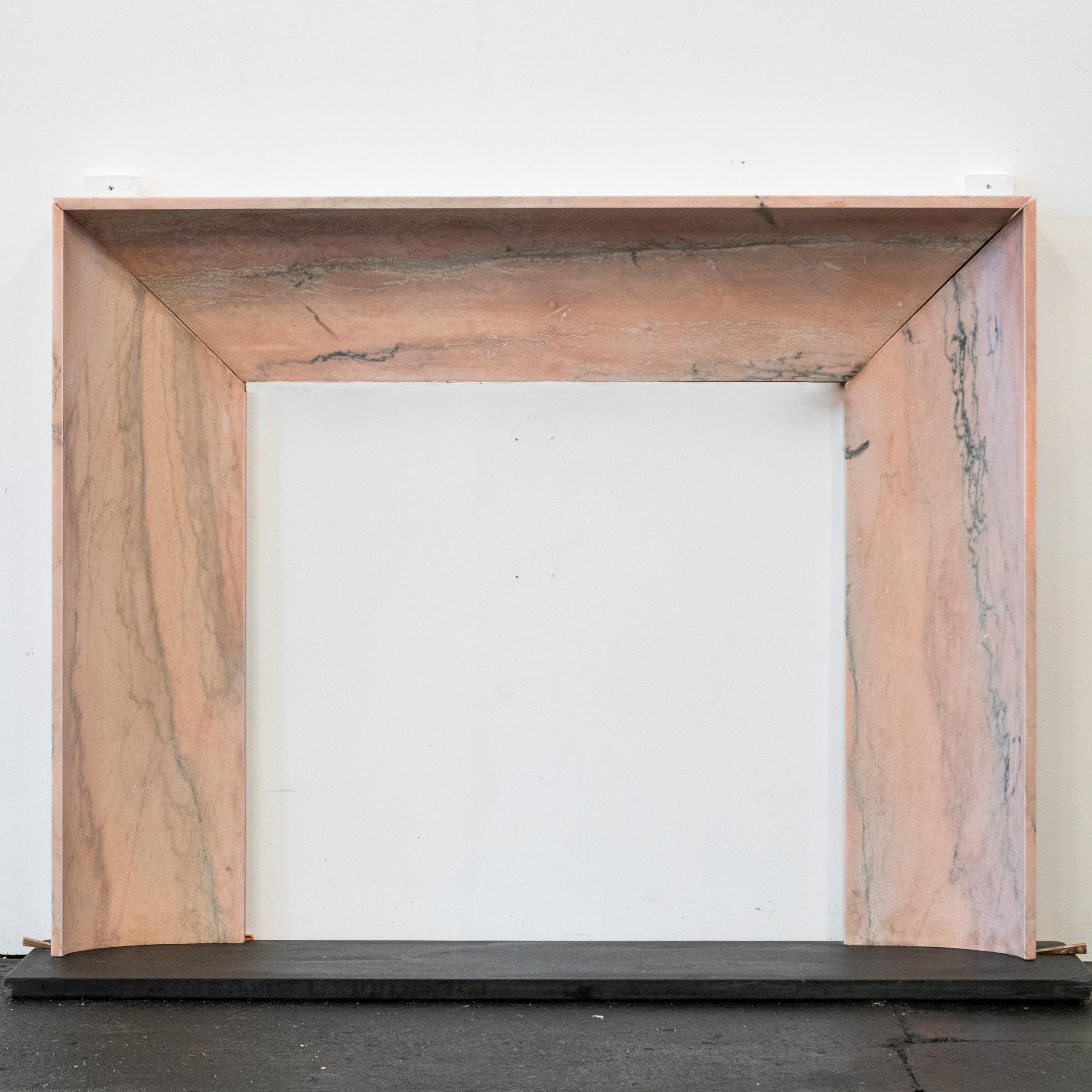 Pretty in pink, this Art Deco-inspired fireplace surround crafted from reclaimed Portuguese Rossa Aurora Marble, highlights the stone’s natural pink hues through its clean, understated design.

Created from 3 carved solid blocks, the Bolection