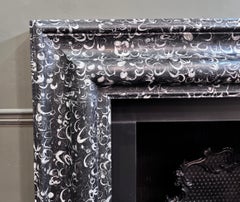 Bolection mantel made from Occhio di Pavone marble by RYAN AND SMITH