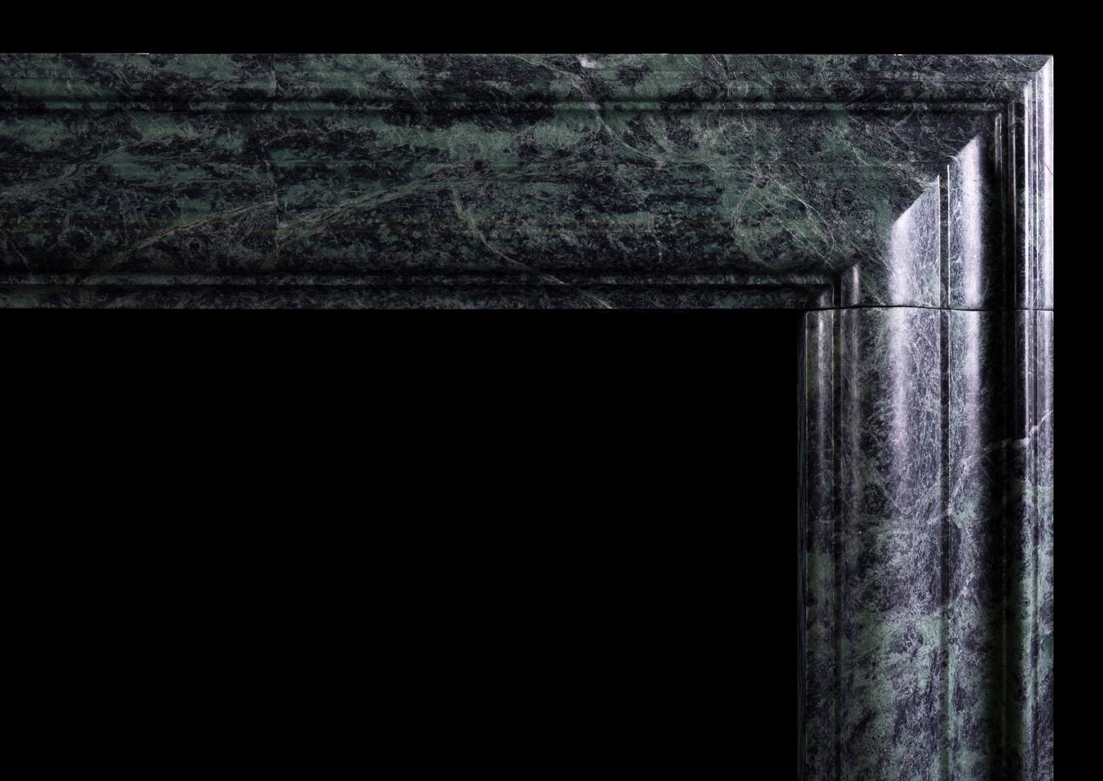 An English moulded bolection fireplace in dark green marble. Based on a period original from the early 18th century. An elegant shape. Modern.

Measures: 
Shelf Width:	1435 mm      	56 1/2 in
Overall Height:	1105 mm      	43 1/2 in
Opening