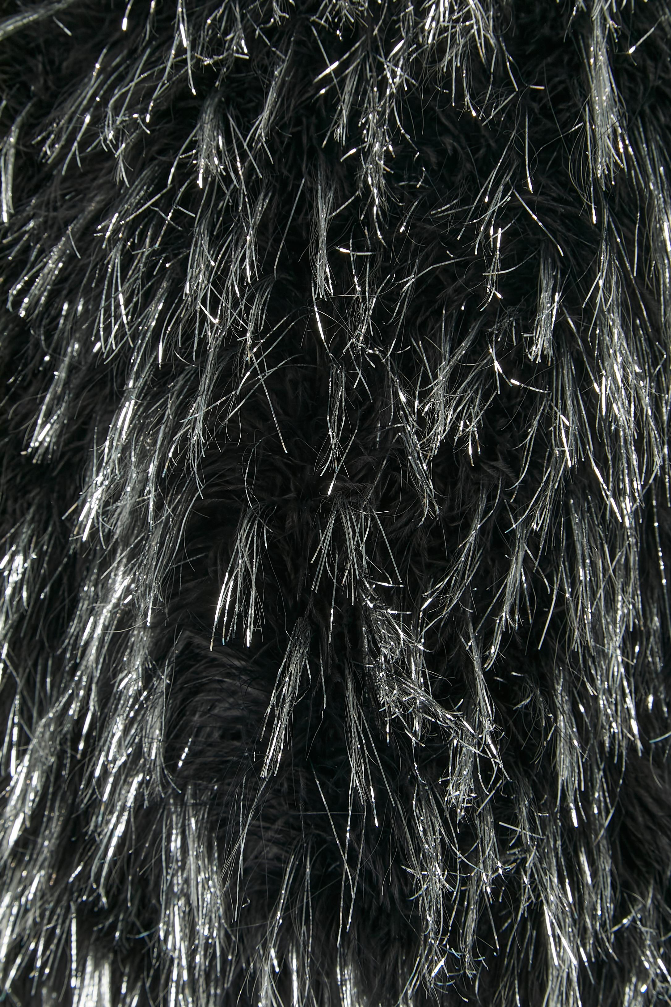 boléro made of black feather and silver thread . No fabric composition tag but the lining is probably rayon or acetate. 2 hook&eye closure on the middle front, one on the top, one on the bottom. 
SIZE M 
