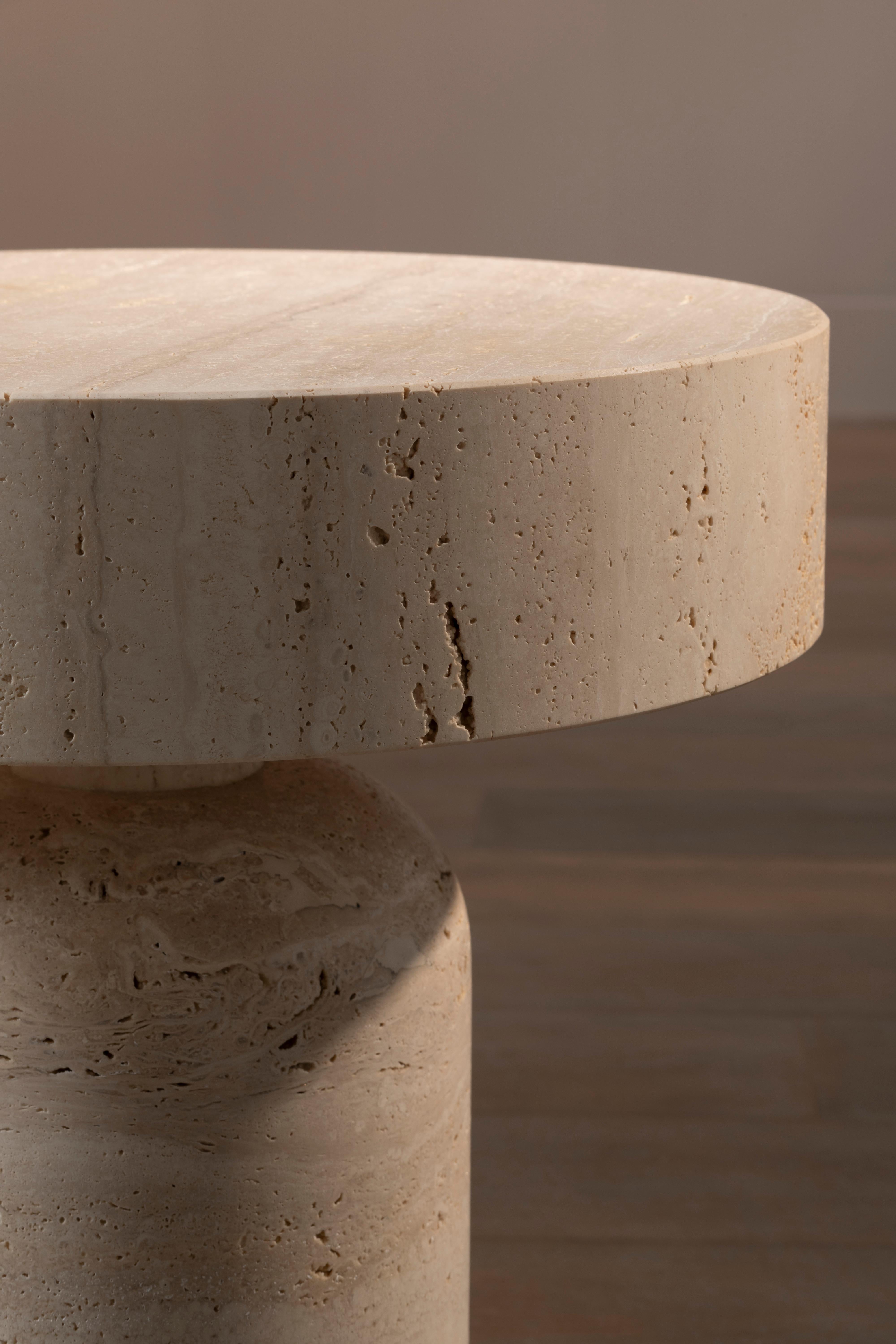 The Boletus Side Table by Bellavista is a stunning piece that combines elegance and functionality. Its structure is crafted from solid honed Travertino marble, known for its unique texture and natural beauty. The leather finish adds a touch of