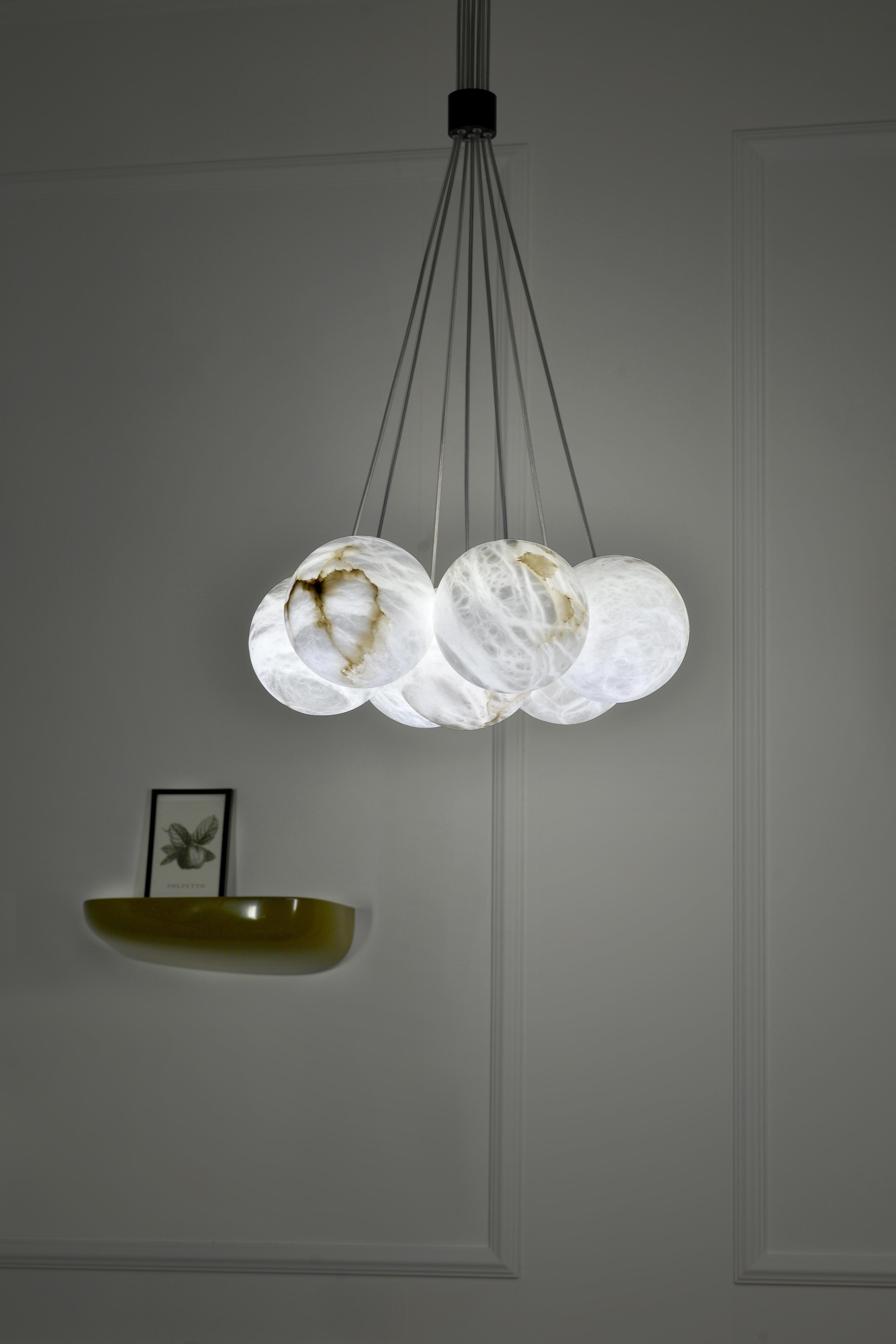 Bolky Up Chandelier by Atelier Alain Ellouz
© Atelier Alain Ellouz 
Dimensions: Ø 17.7 in x h. min. 35.4in
Materials: Bolky up 7 : 7 Alabaster spheres Ø5,9’’, Steel painted mat black
Weight: 20 lb 

Suspension system: Wire + transparent cable
