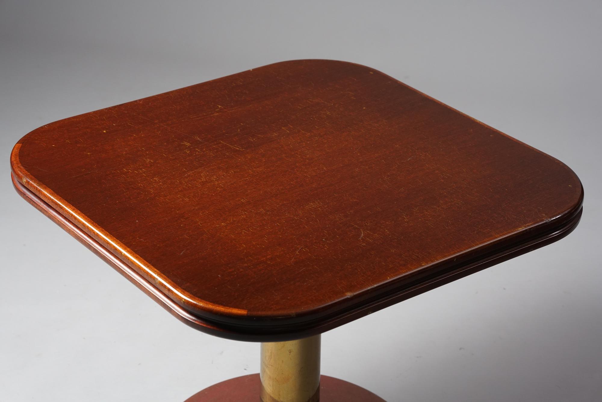 Rare table basse fabriquée par Boman OY. Pied en laiton lourd avec une surface en bois.