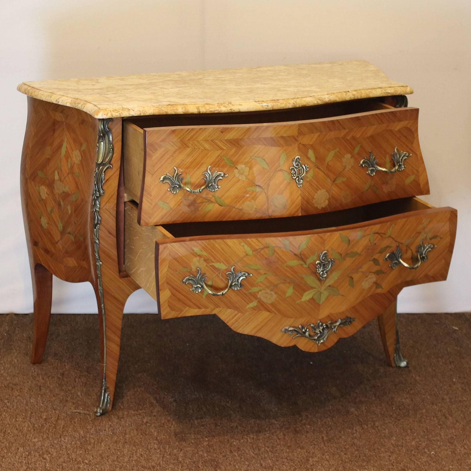Decorative bombe commode with superb fruitwood inlay work and ormolu decoration. This commode has beautifully shaped legs, colored marble-top and two deep working drawers.