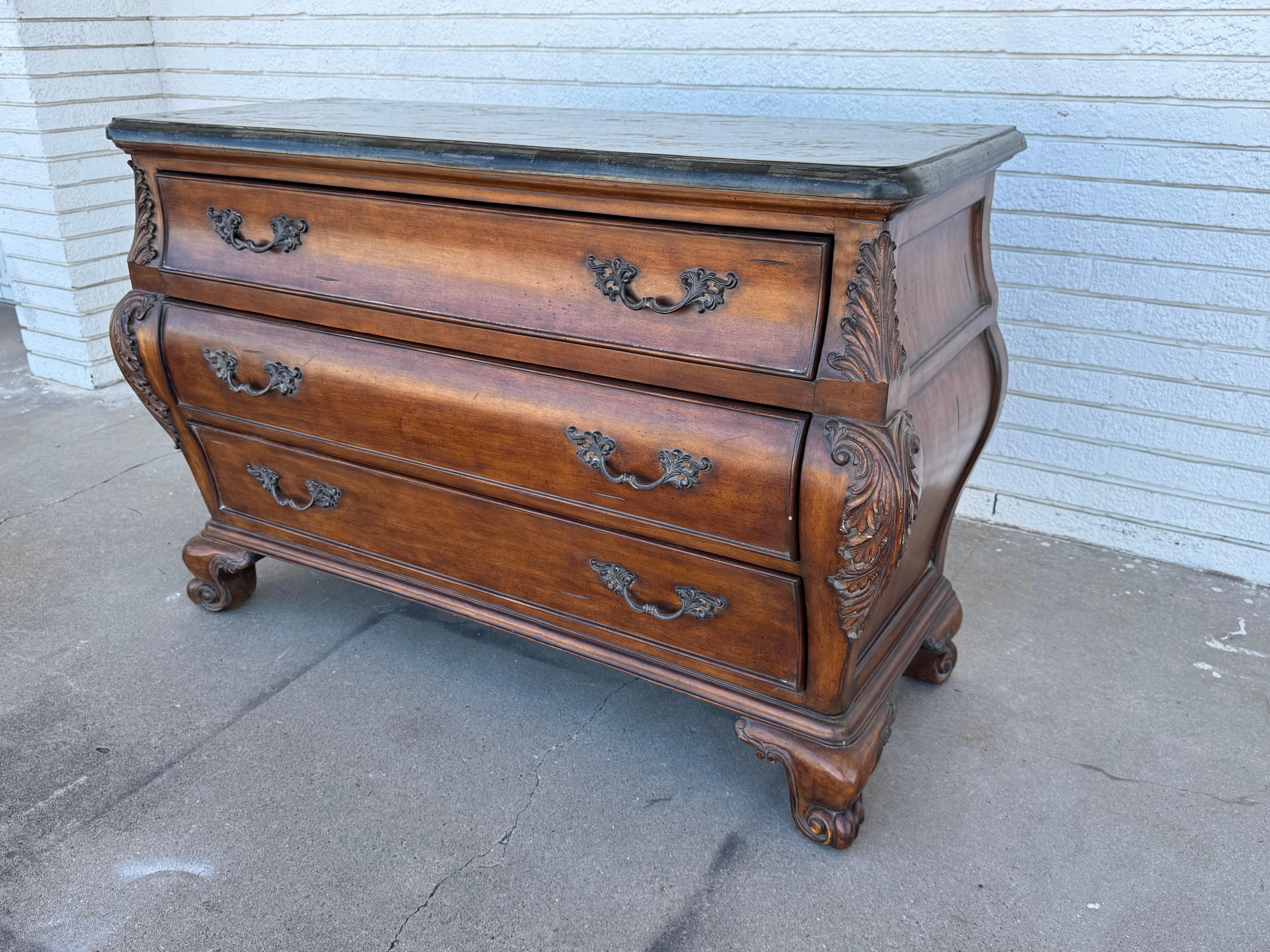 This 3 drawer chest is made of walnut and has a checkerboard granite top. The elbows are nicely carved as they accentuate the bow in the craftsmanship. The granite top is 2