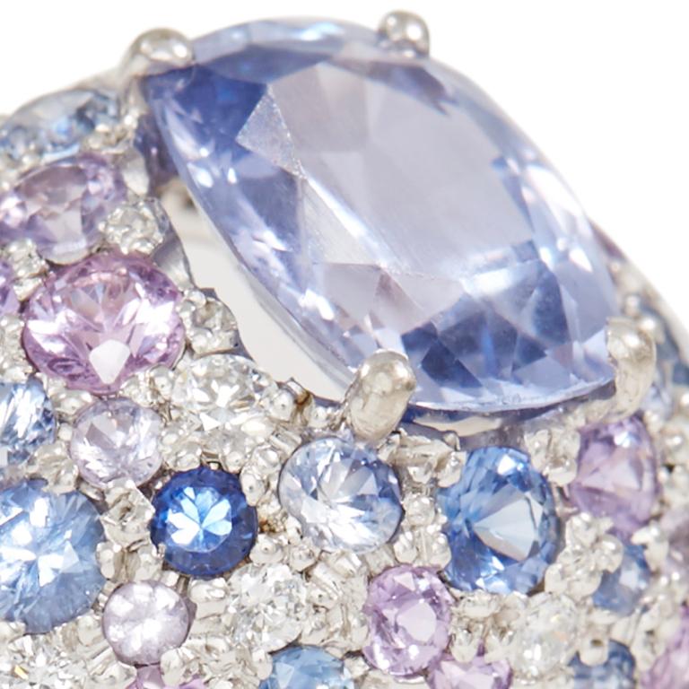 Central cushion cut violet sapphire surrounded by pavé set pink, blue and violet sapphires with diamonds in 18 carat white gold. Ring available in size O. 

Esther Eyre has been designing and making precious jewellery for over twenty years. She