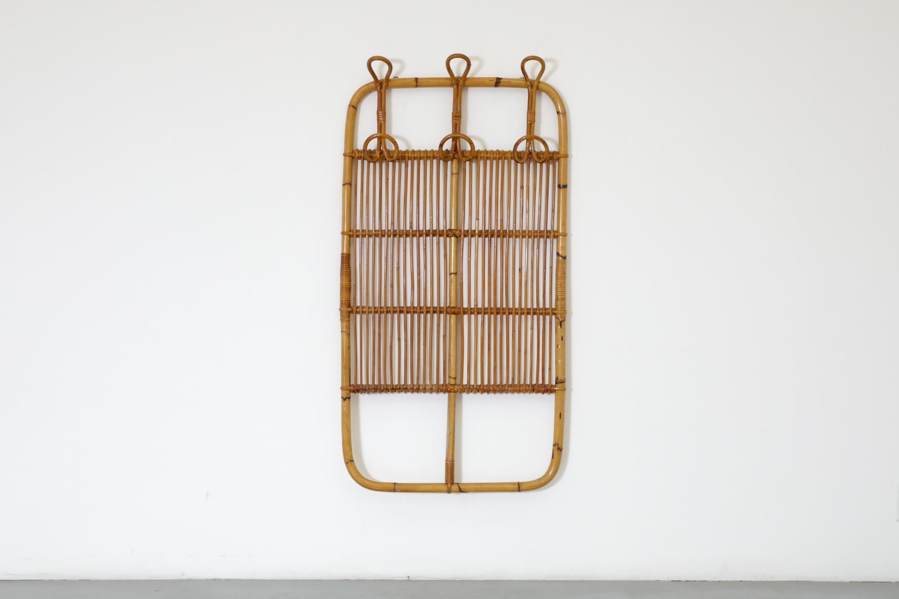 Appendiabiti da parete in bambù con ganci e accenti in rattan nello stile di Franco Albini. In condizioni originali, con una bella patina e un'usura visibile. La rottura del bambù è minima. L'usura è coerente con l'età e l'uso.