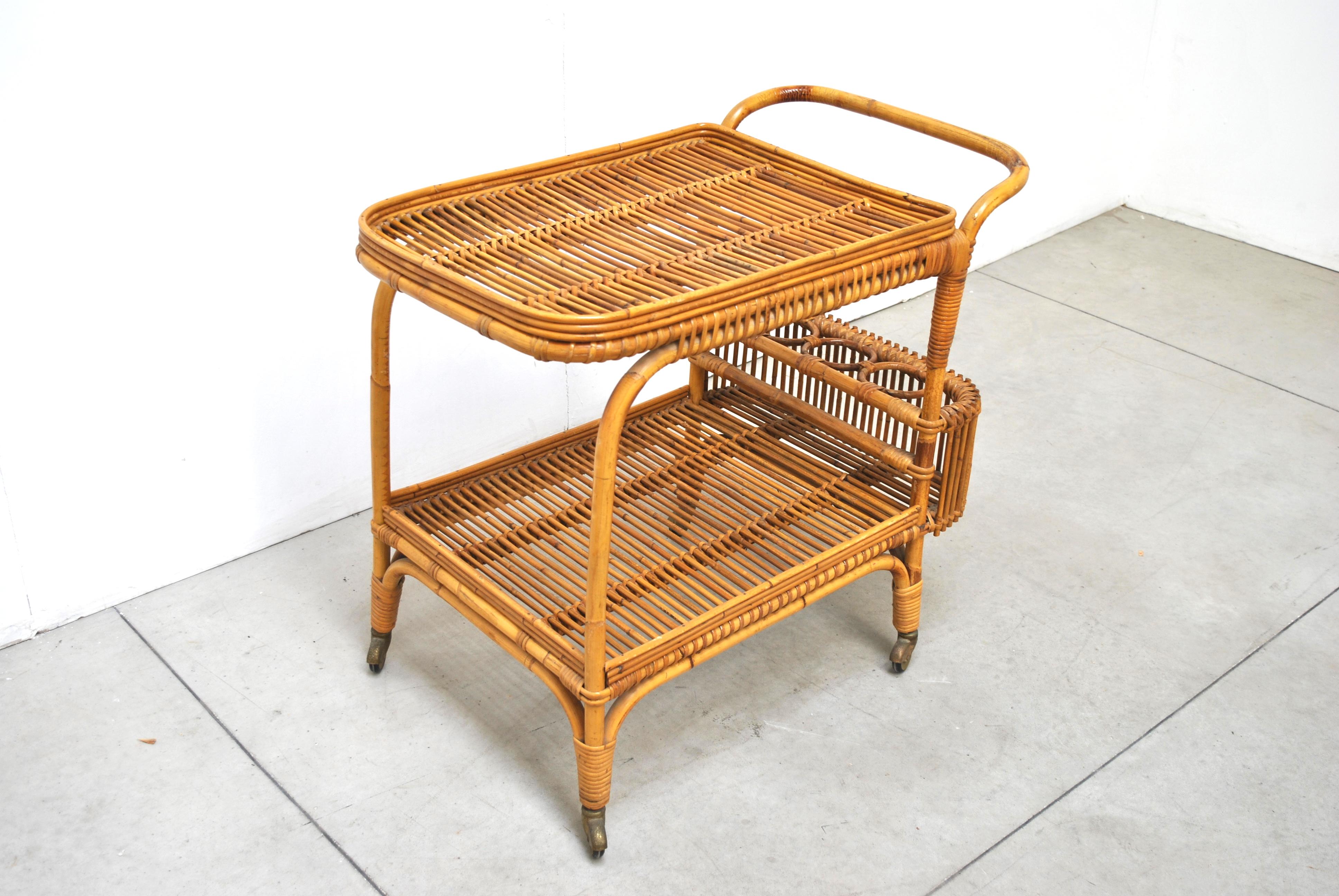 Fabulous bar cart from the 1950s. Made in bamboo and wicker with two large wheels. Bottle rack on the back.