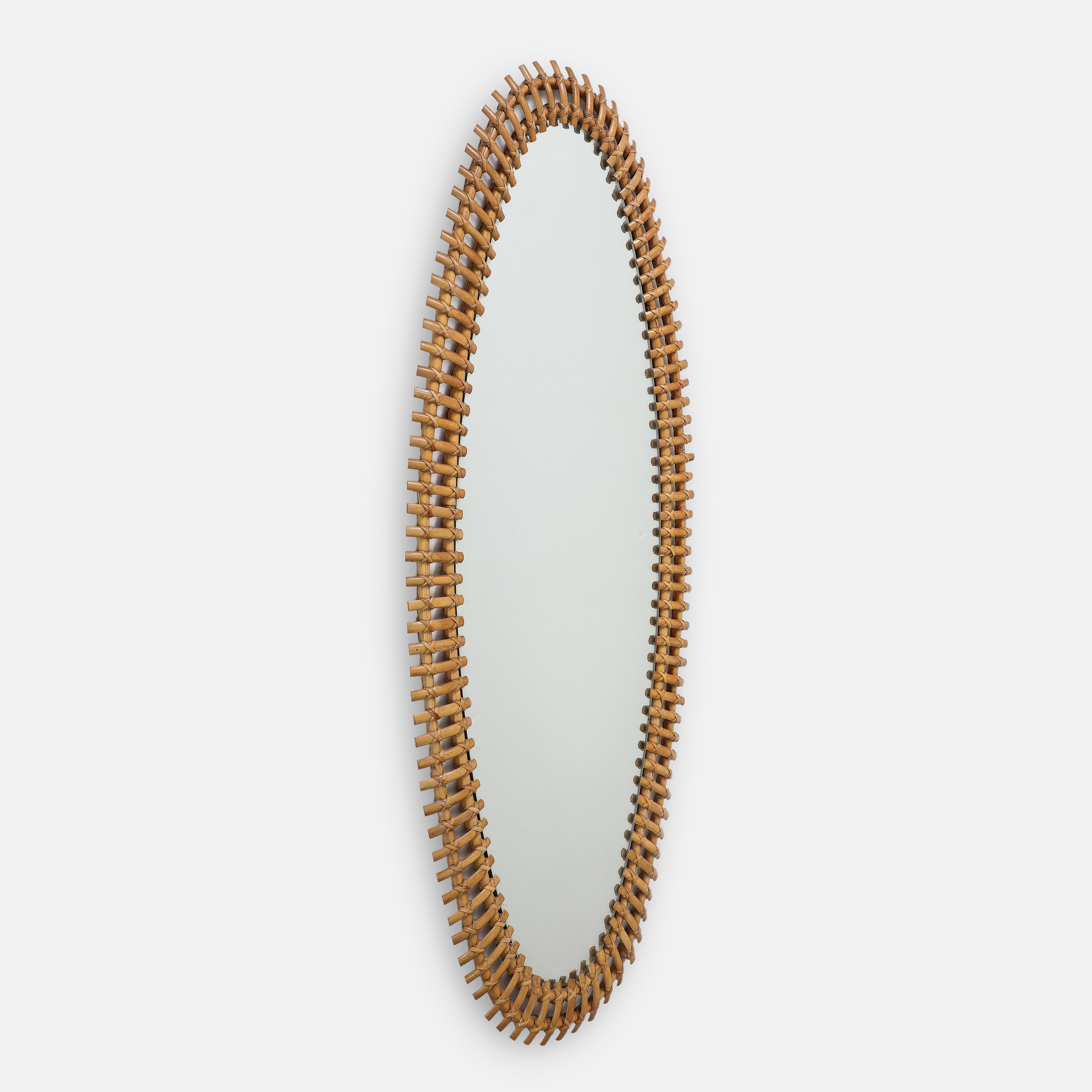 Bonacina rare grand scale oval mirror with slightly curved bamboo pieces hand-woven on frame of double bamboo rods with original mirrored glass. This monumental mirror is striking in size and elegant in its simple organic design and will compliment