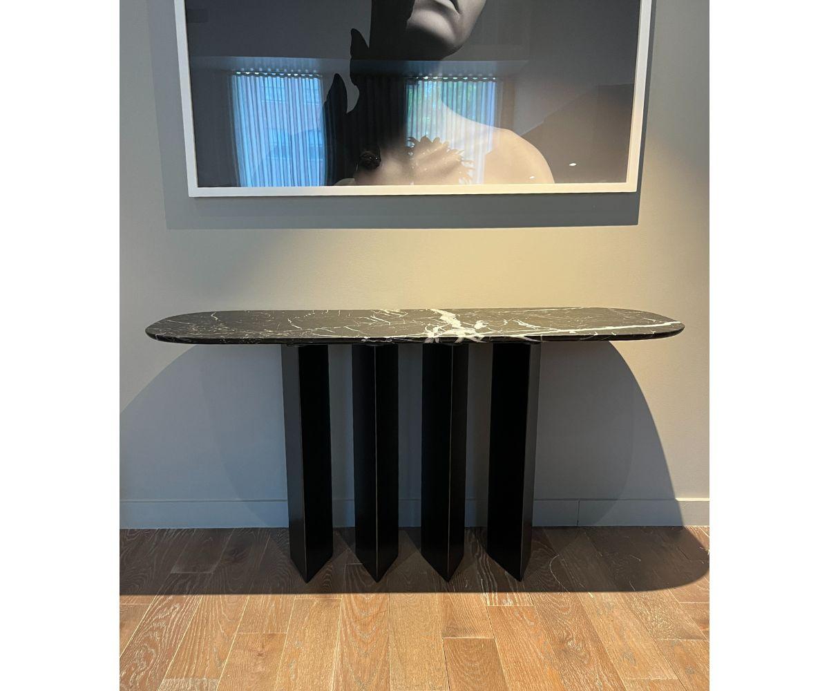 La console géométrique Bonaldo fait une déclaration audacieuse avec son design frappant et ses courbes gracieuses. Sa base est composée de quatre pieds en forme de goutte d'eau, à la fois massifs et élégants, ce qui confère à la pièce un aspect