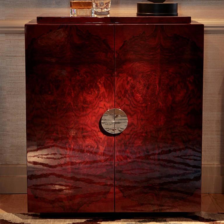 Designed by Simon Stewart for Charles Burnand. The deco inspired, Bond Drinks cabinet is made from stained walnut burr veneer high gloss lacquer exterior with high gloss maple, mirror interior with glass shelves inside the doors. The cabinet sits on