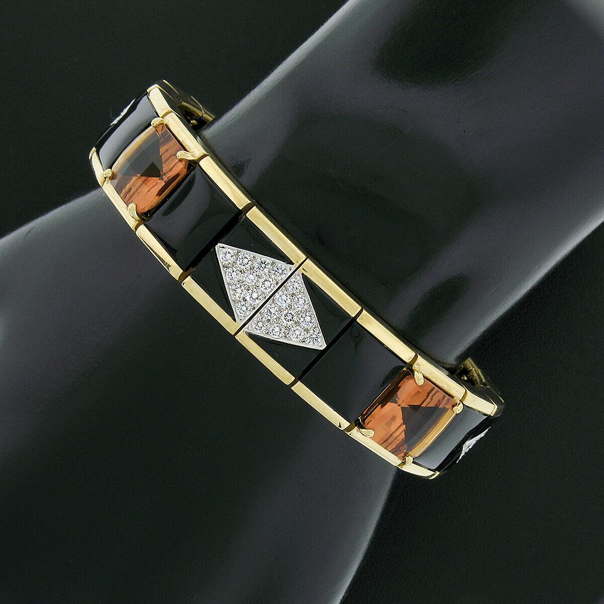 This magnificent statement bracelet was designed by Michael Bondanza and crafted from solid 18k yellow gold and platinum. It features wide rectangular links with a nice polished finish in which are neatly set with fine black onyx, citrine, and