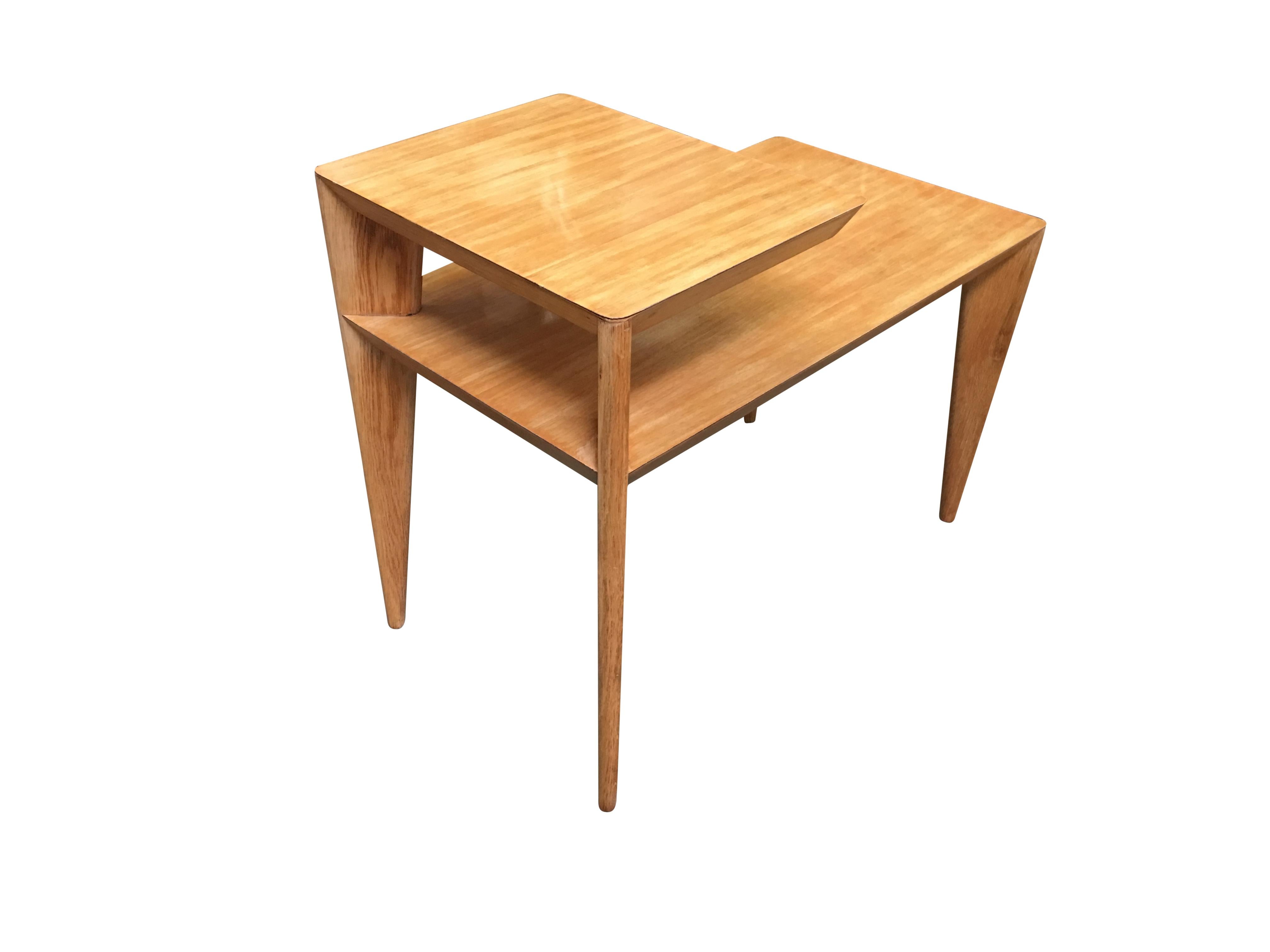 Blonde Mid Century knife leg modernist two-tier side table pair featuring a high style geometric form with pointed knife style legs and formica tops.