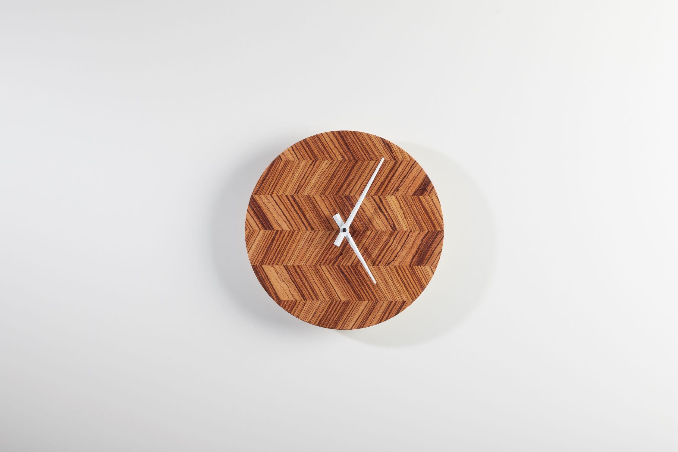 Revitalize your decor with these stunning wall clocks, featuring an alluring design crafted from natural zebrano veneer arranged in a mesmerizing fishbone pattern. 

Equipped with a high-quality branded battery mechanism, these clocks seamlessly