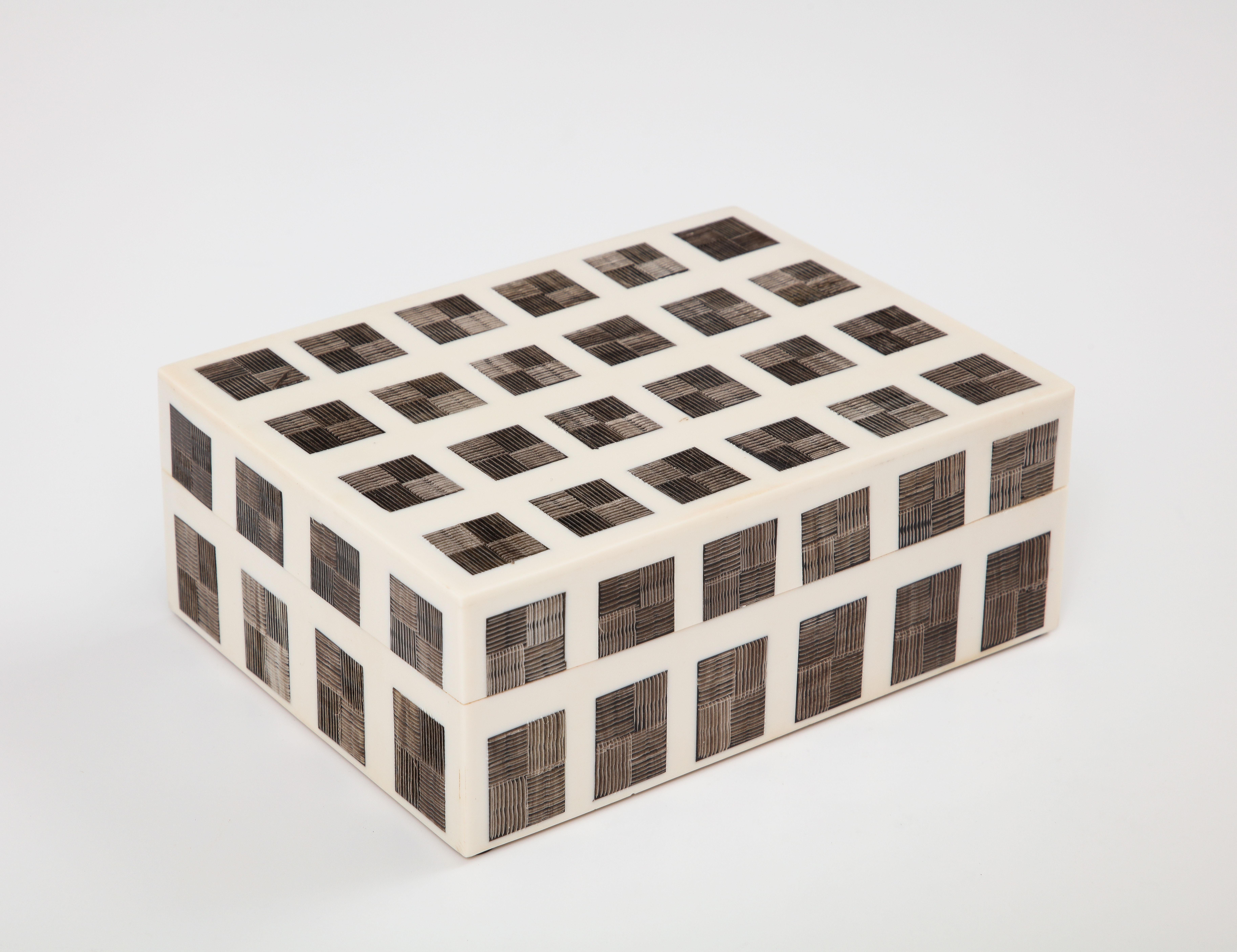 Decorative bone box inset with hand incised horn tiles creating a grid pattern, lined in wood.