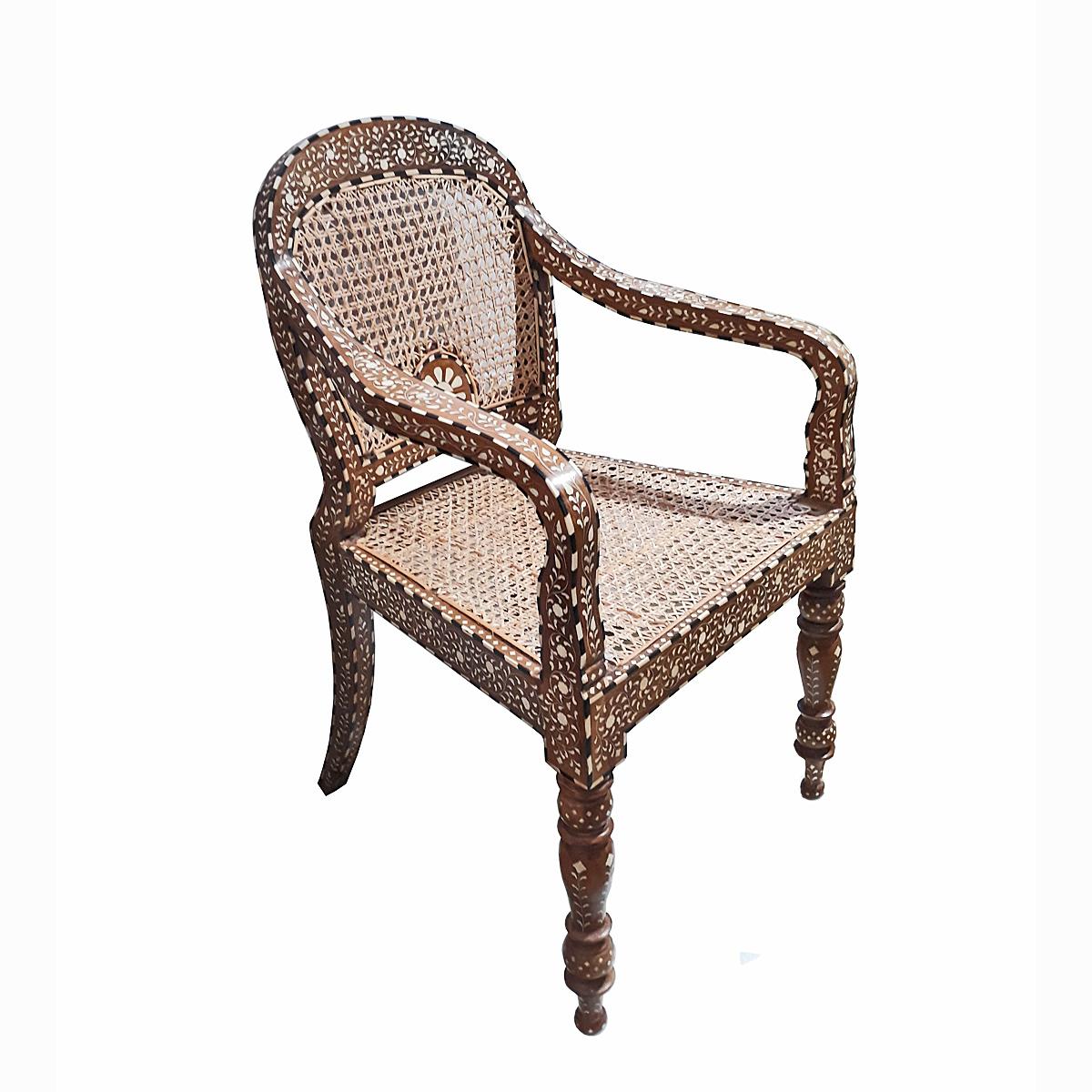 A beautiful armchair, handcrafted in India out of aged and naturally seasoned teak wood, inlaid with cruelty-free sourced bone and artisanally weaved cane. 

Inlay is ancient decorative technique that involves embedding delicate, hand-carved