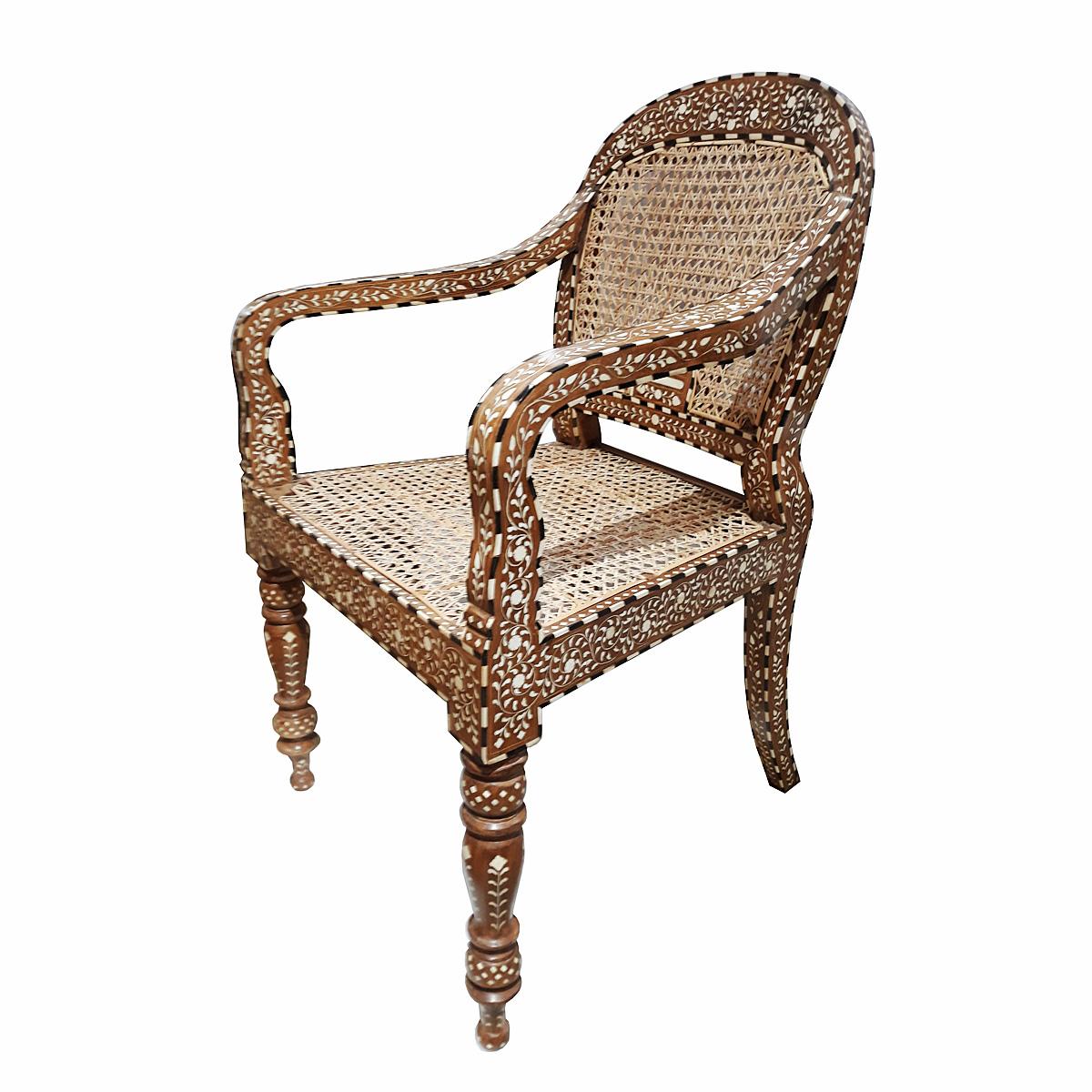 Un magnifique fauteuil, fabriqué à la main en Inde en bois de teck vieilli et naturellement assaisonné, incrusté d'os provenant de sources sans cruauté et de canne tressée artisanalement. 

La marqueterie est une technique décorative ancienne qui