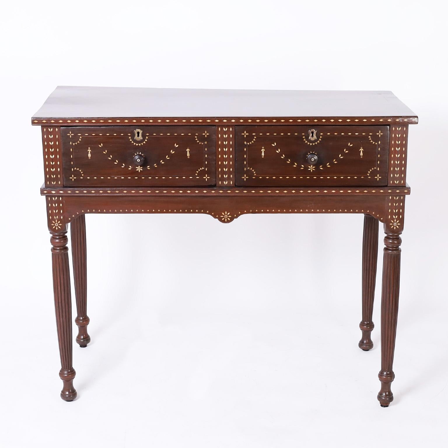 19th century Anglo Filipino British Colonial server or hunt board handcrafted in mahogany with two drawers and decorated with floral and geometric bone inlays on long elegant turned and beaded legs. As seen in the second and third photos, some