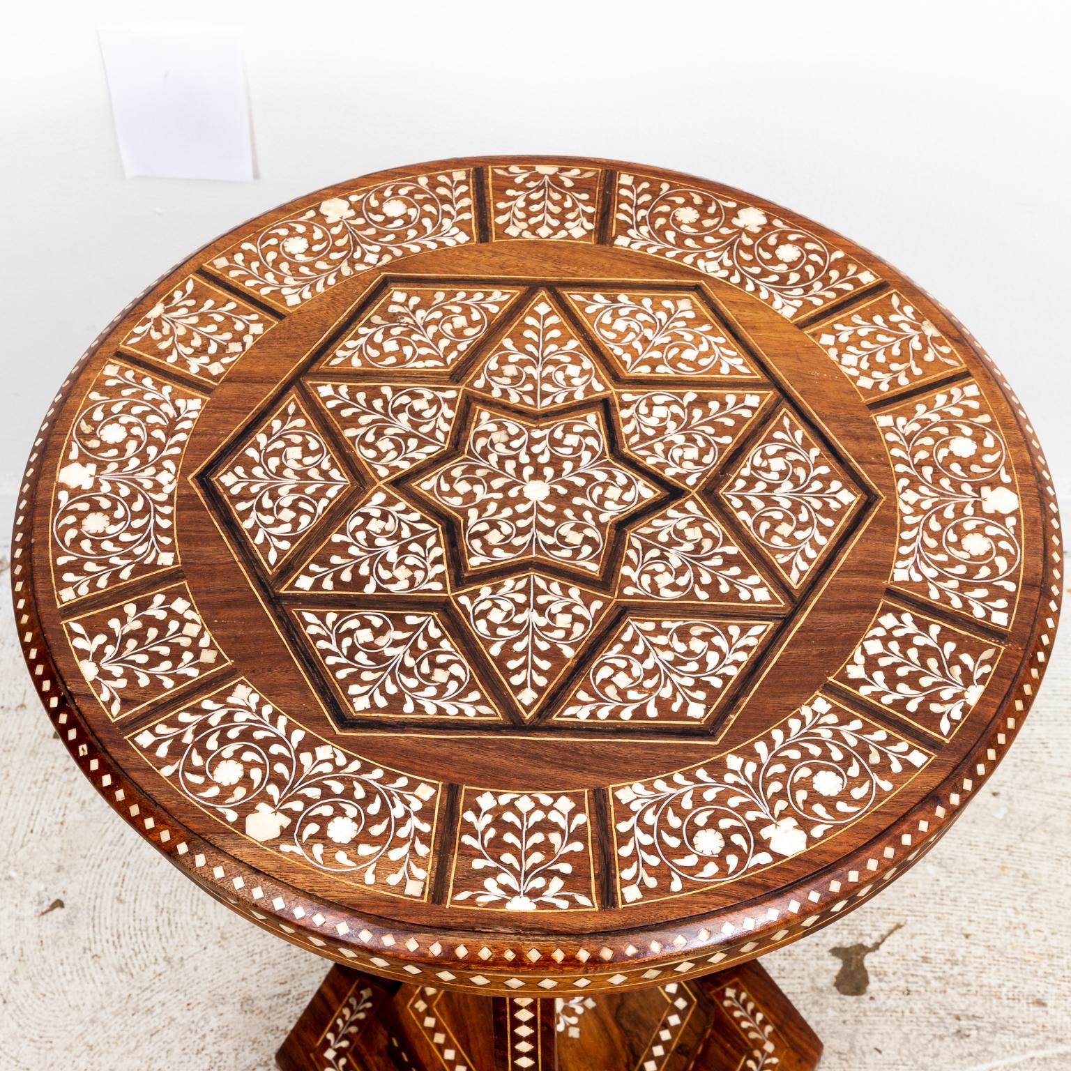 Circa 20th century camel bone inlaid side table with hexagonal base. The table is detailed throughout with scrolled foliage motifs, diamond shaped trim, and a central starburst design on the round tabletop. Please note of wear consistent with age.