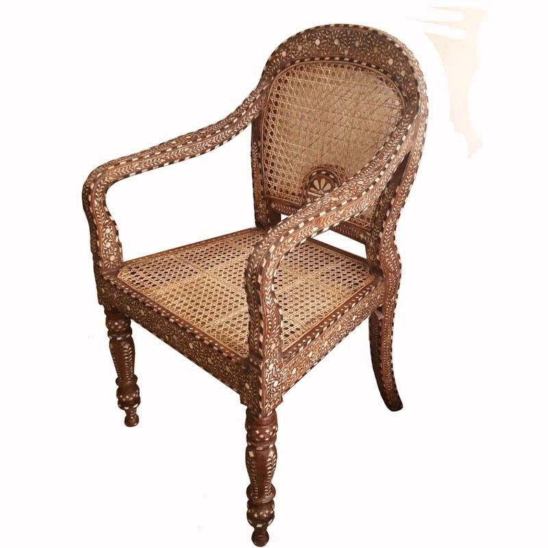 An Anglo-Indian style armchair from India, in traditional teak with bone inlays. Cane mesh seat and back. Classic Indian inlay pattern. Two available.